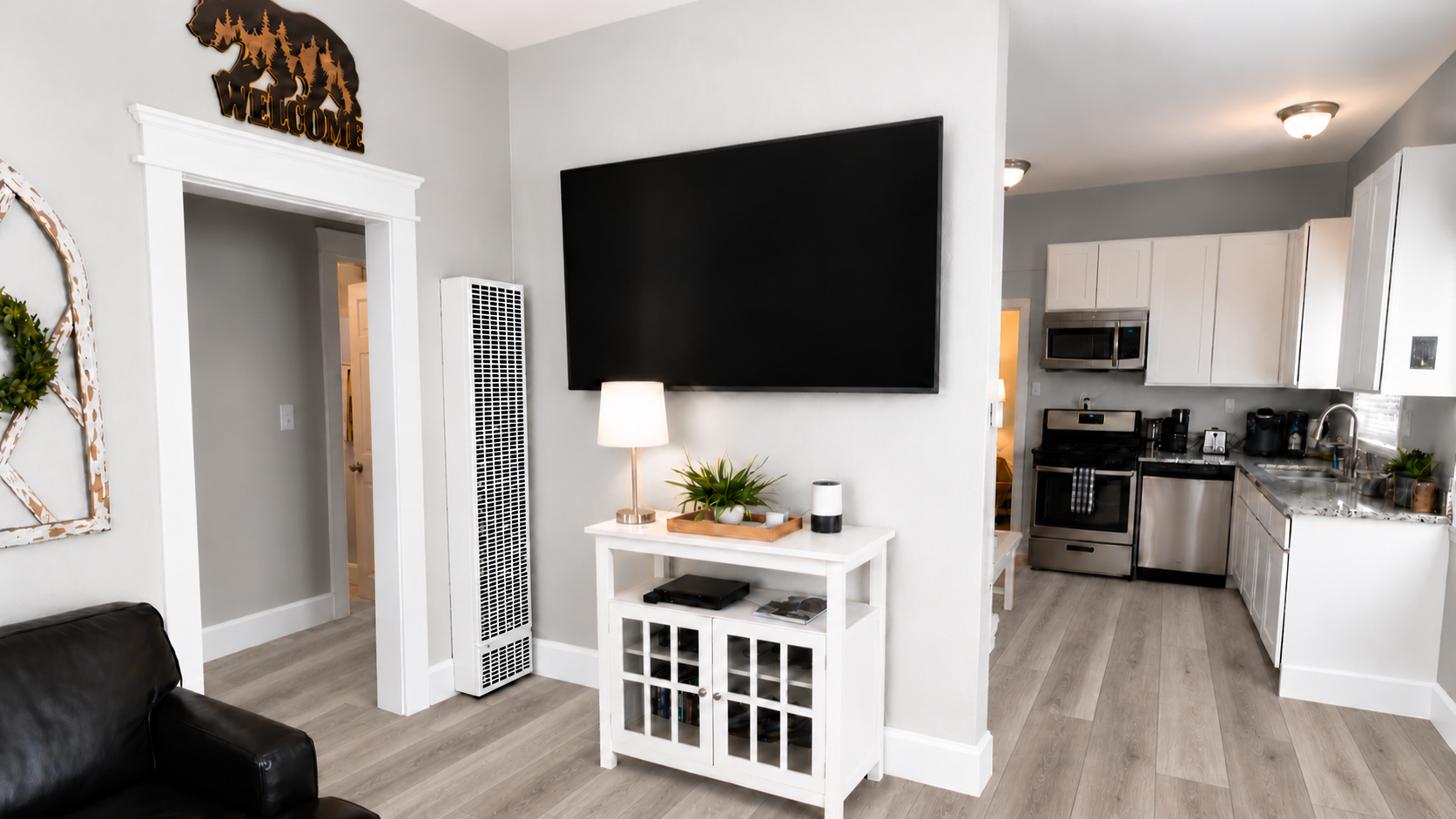 Bright open living area with large TV and modern full kitchen