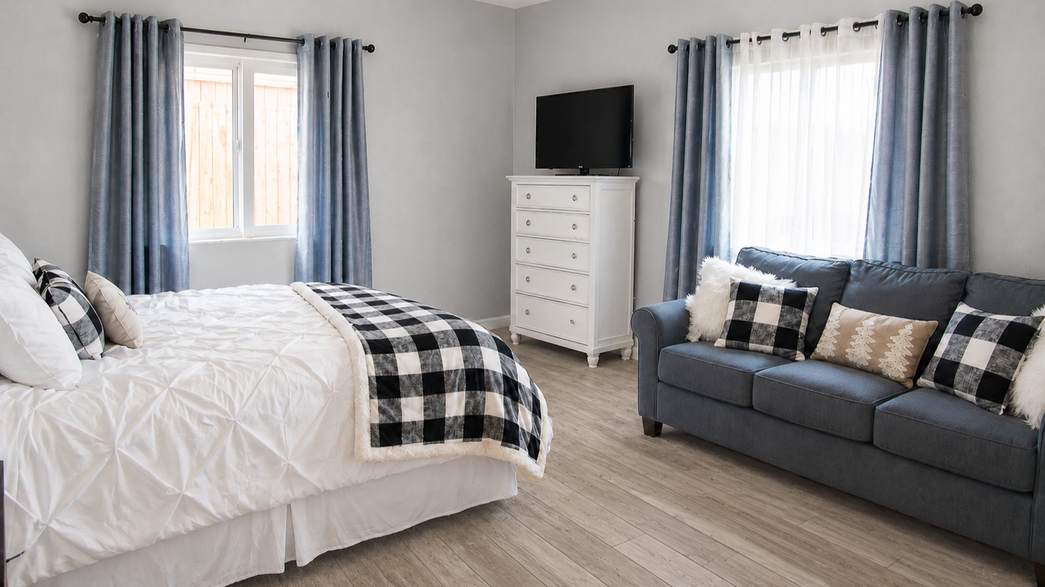 Bright, spacious bedroom with cozy sofa, TV, and stylish modern touches