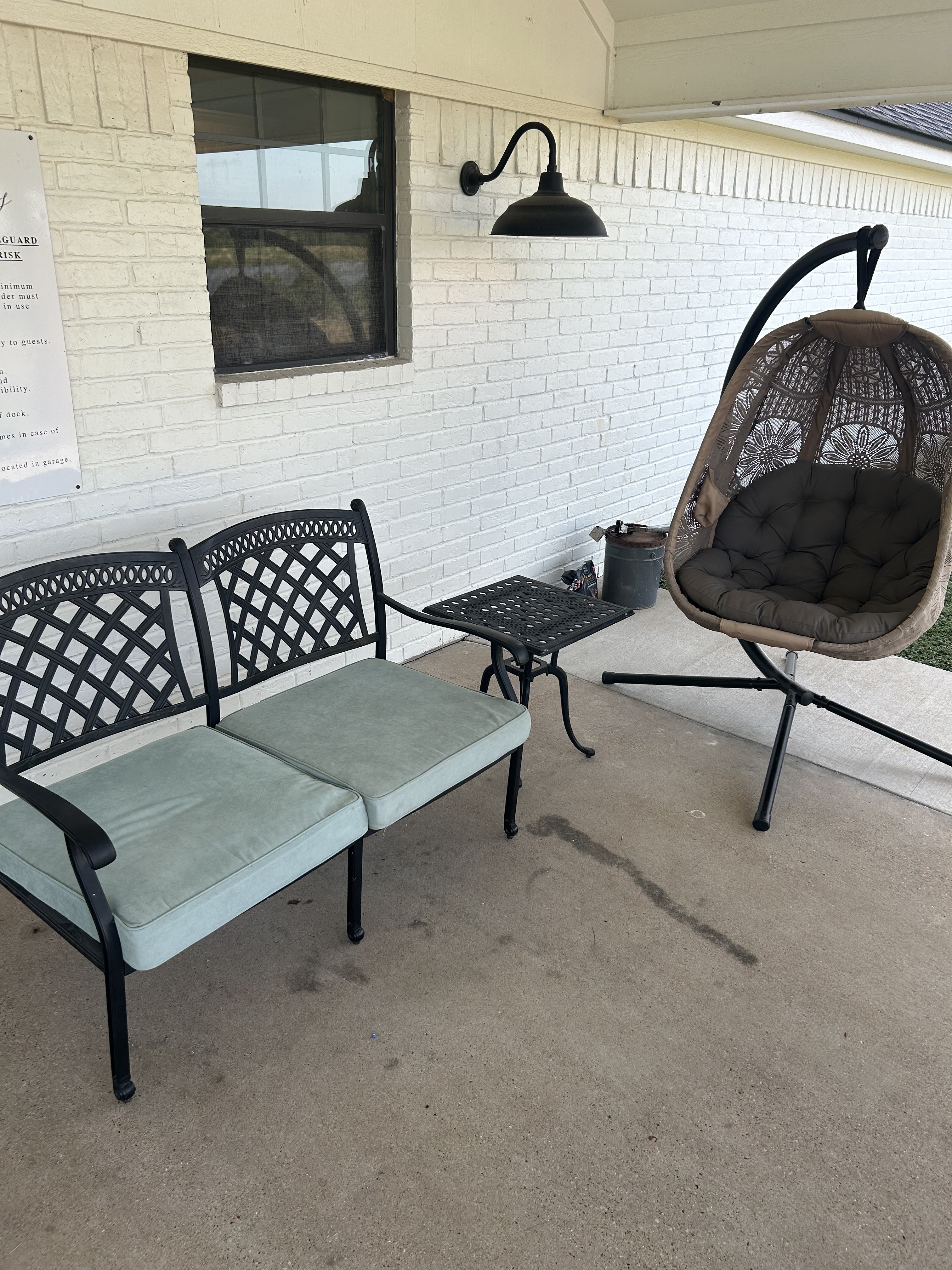 Cozy covered patio with cushioned seating and hanging egg chair