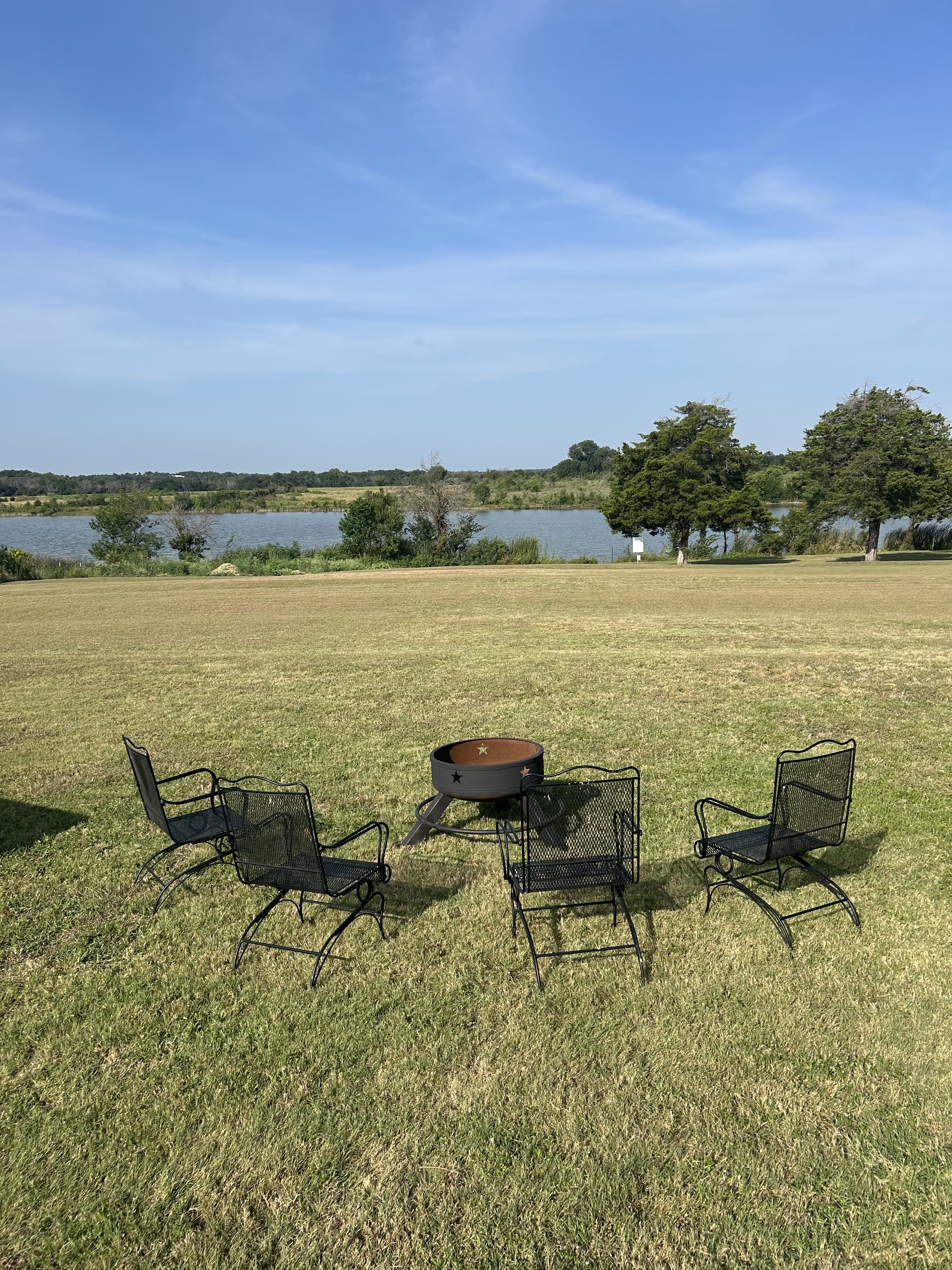 Relax by the fire pit with wide-open lawn and peaceful water views