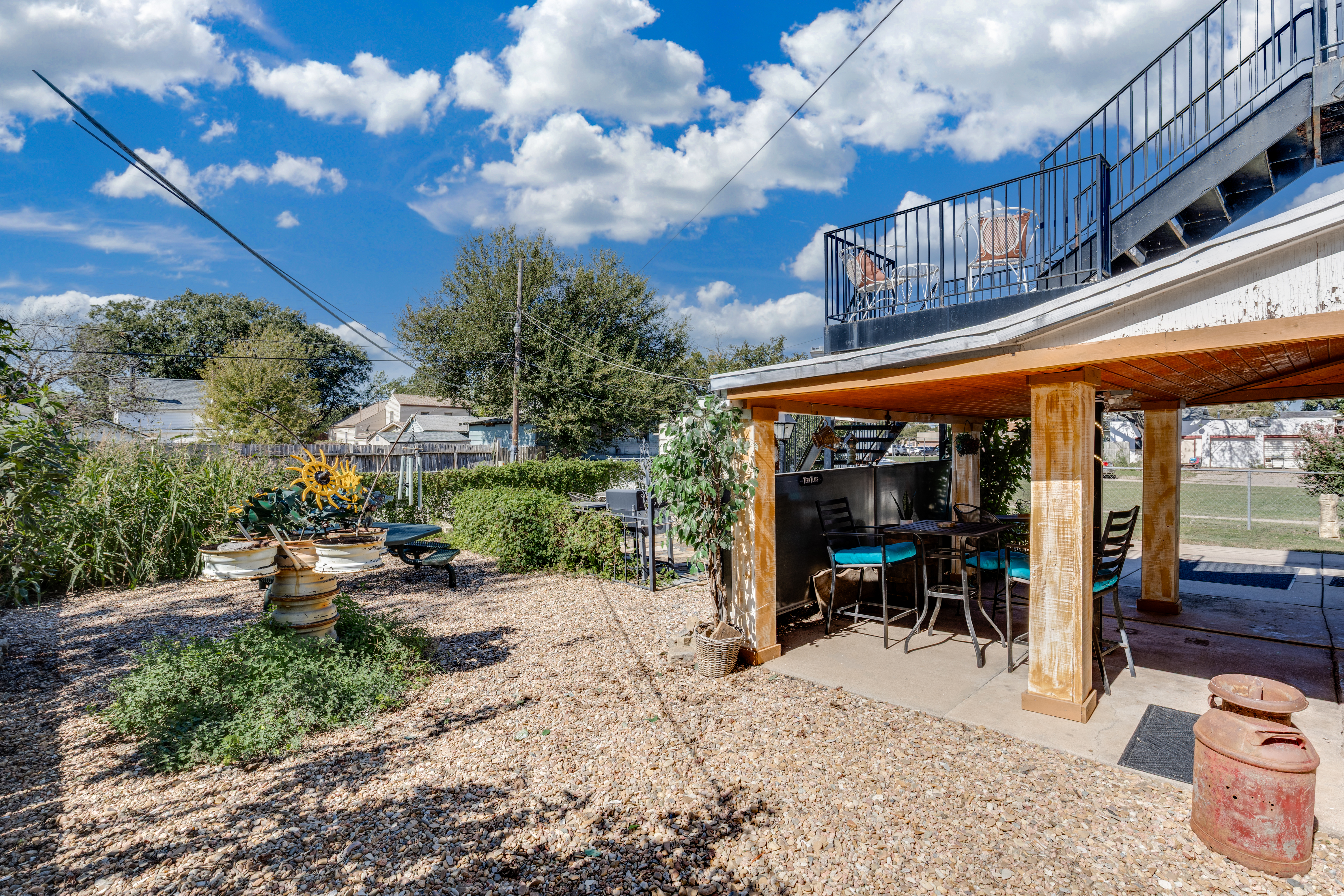Sunny backyard with covered patio bar and spacious outdoor hangout area
