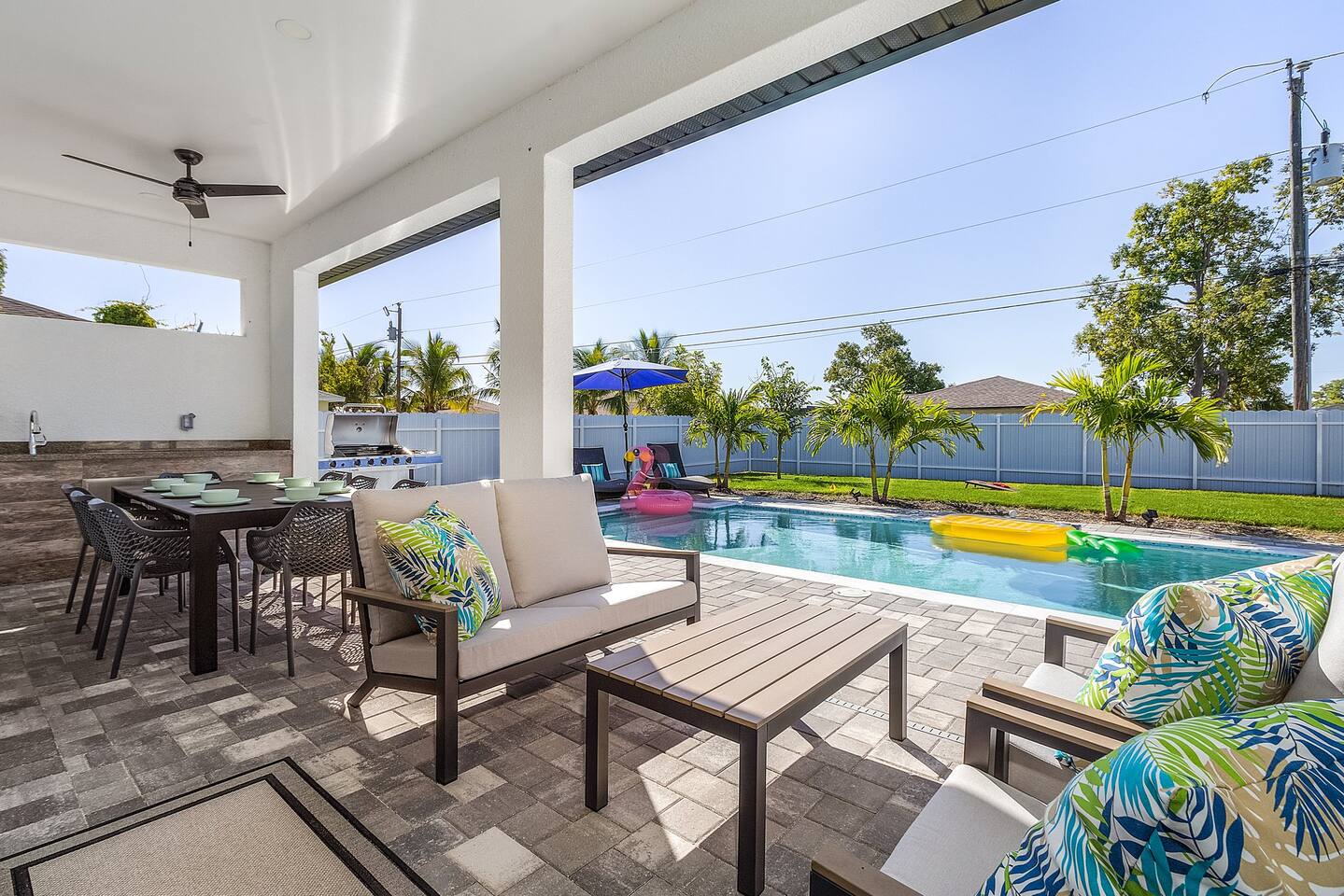 Lanai with comfortable seating and a dining area under ceiling fans