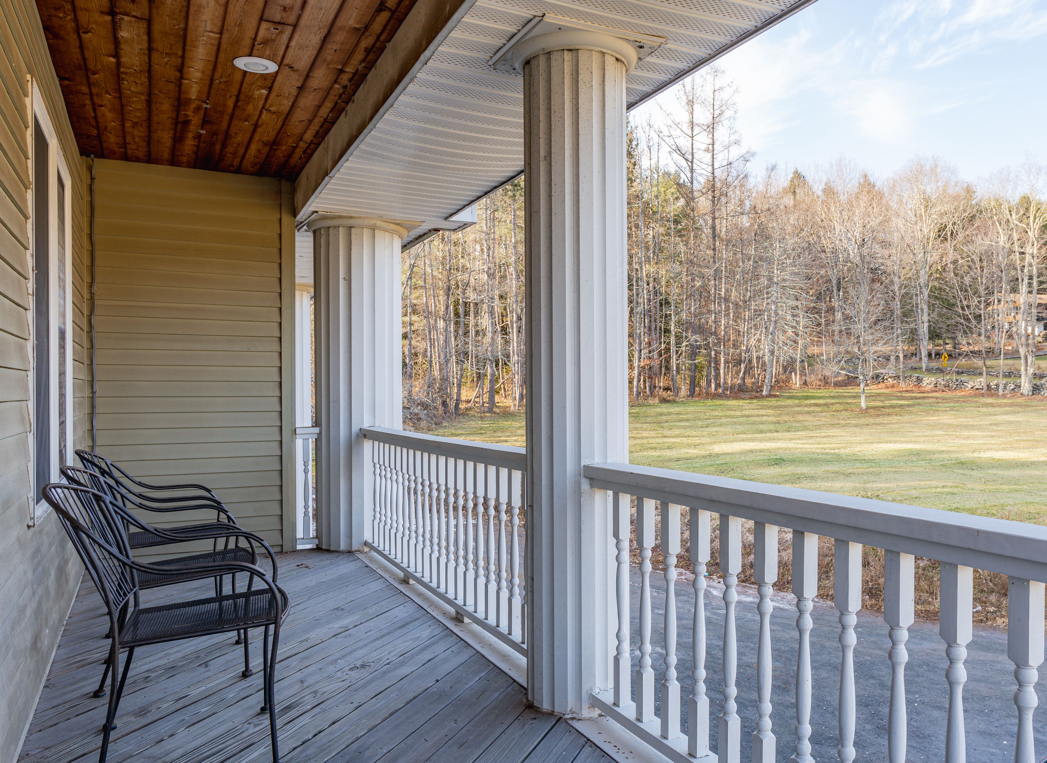 Relax on the covered porch with peaceful lawn and woodland views