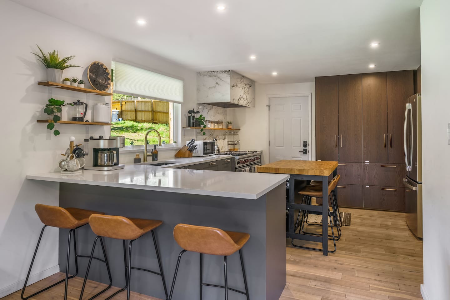 Kitchen breakfast counter with leather stools and open shelving