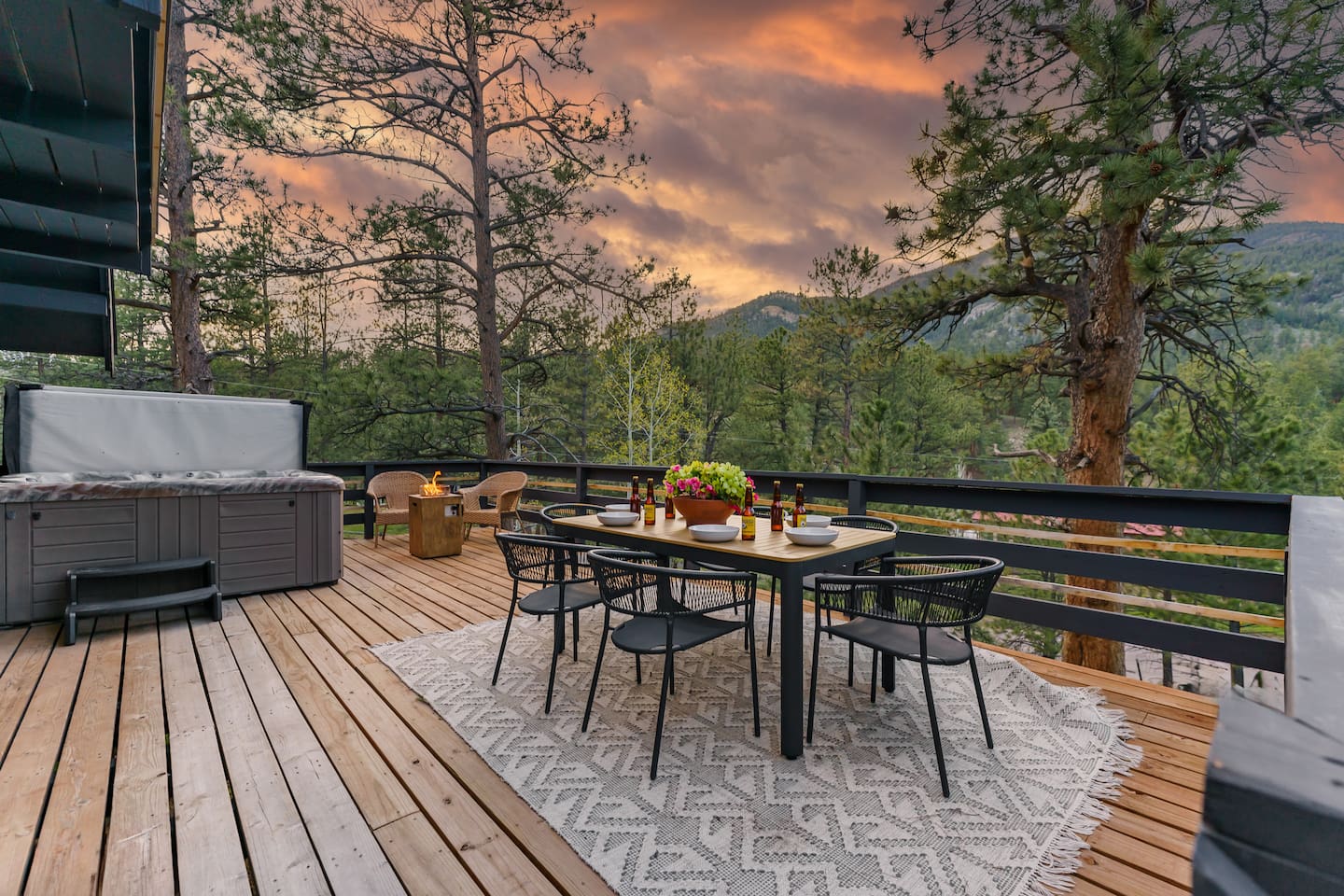 Outdoor dining table for six on the deck at sunset, with the hot tub nearby