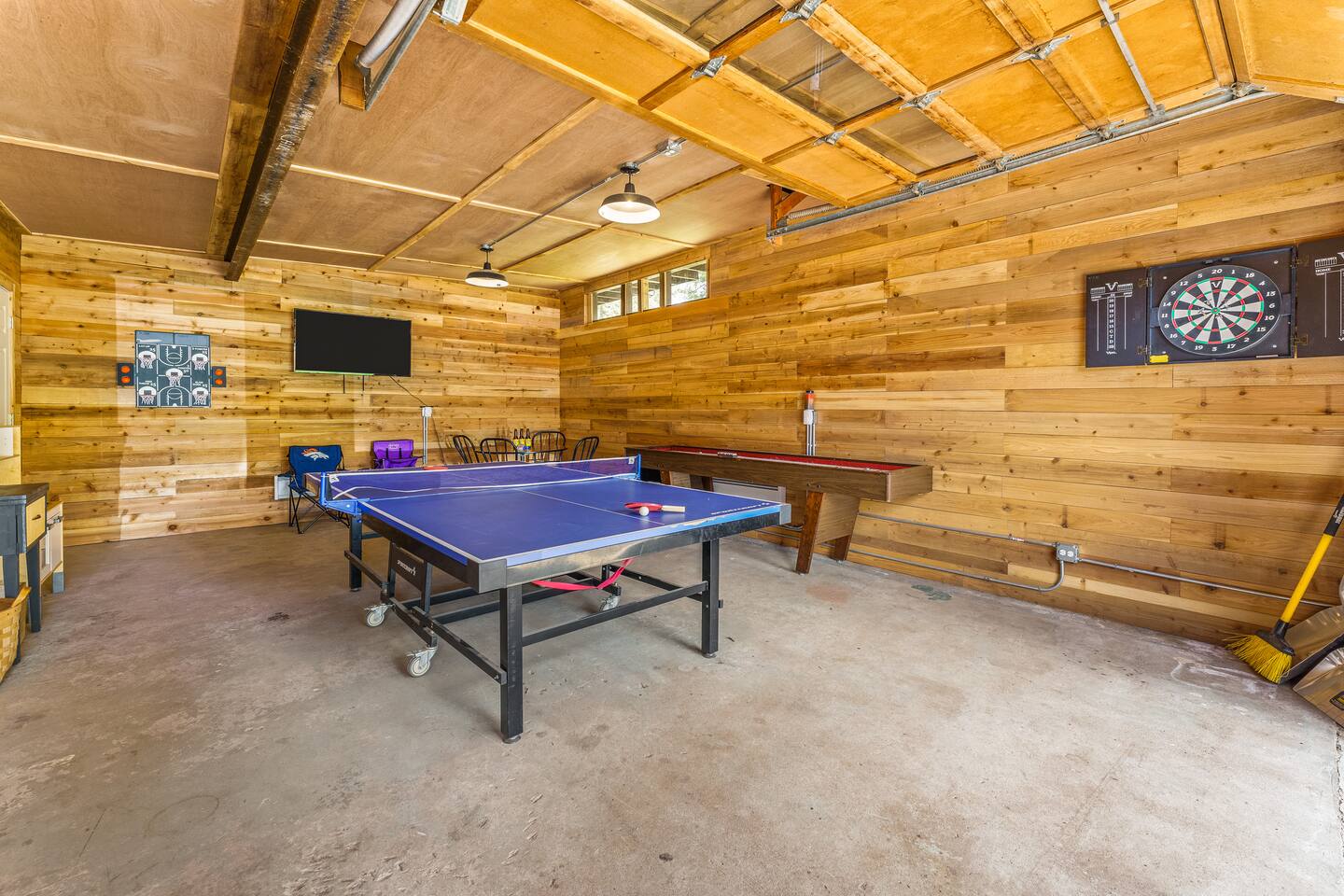 Game room with a ping pong table, shuffleboard and a dartboard