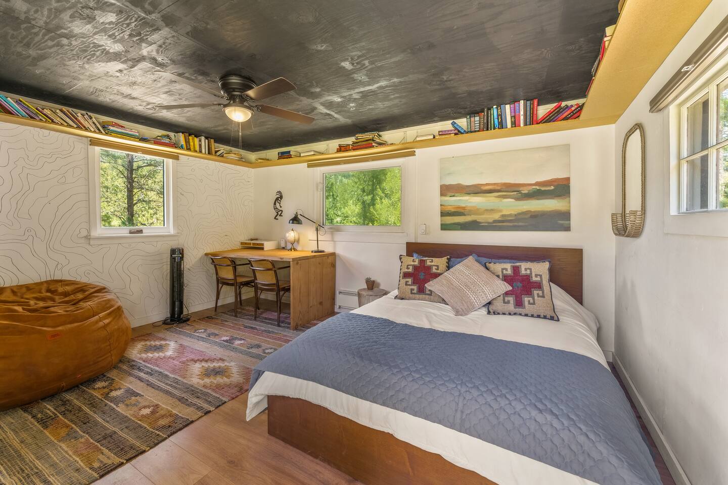Writer’s Nook bedroom with a queen bed, a desk, a beanbag and an elevation-map mural