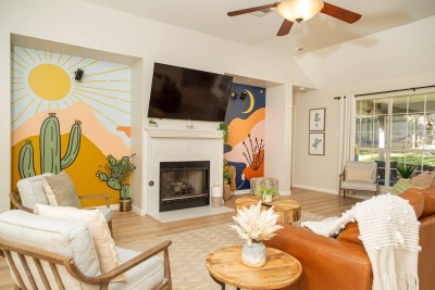 Boho Chic Living Room! ☀️ This vibrant space features custom desert murals and a cozy fireplace. Relax on the comfy leather sectional while enjoying the large Smart TV. Vaulted ceilings and soft wood tones create a perfect gathering spot!