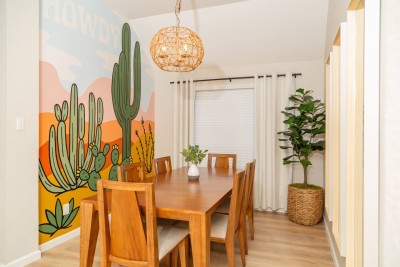 Vibrant Dining Area! ️ Gather around the wooden dining table beneath a stunning boho chandelier. Features a custom cactus mural and comfortable seating for six. A bright, fun spot for meals, games, or planning your adventures! Uniquely designed!