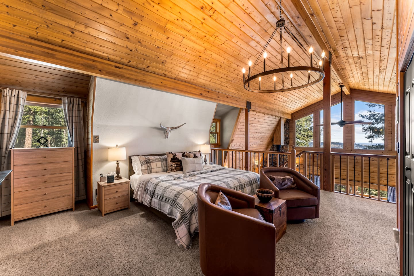 Primary loft suite with a king bed, a chandelier and an electric fireplace