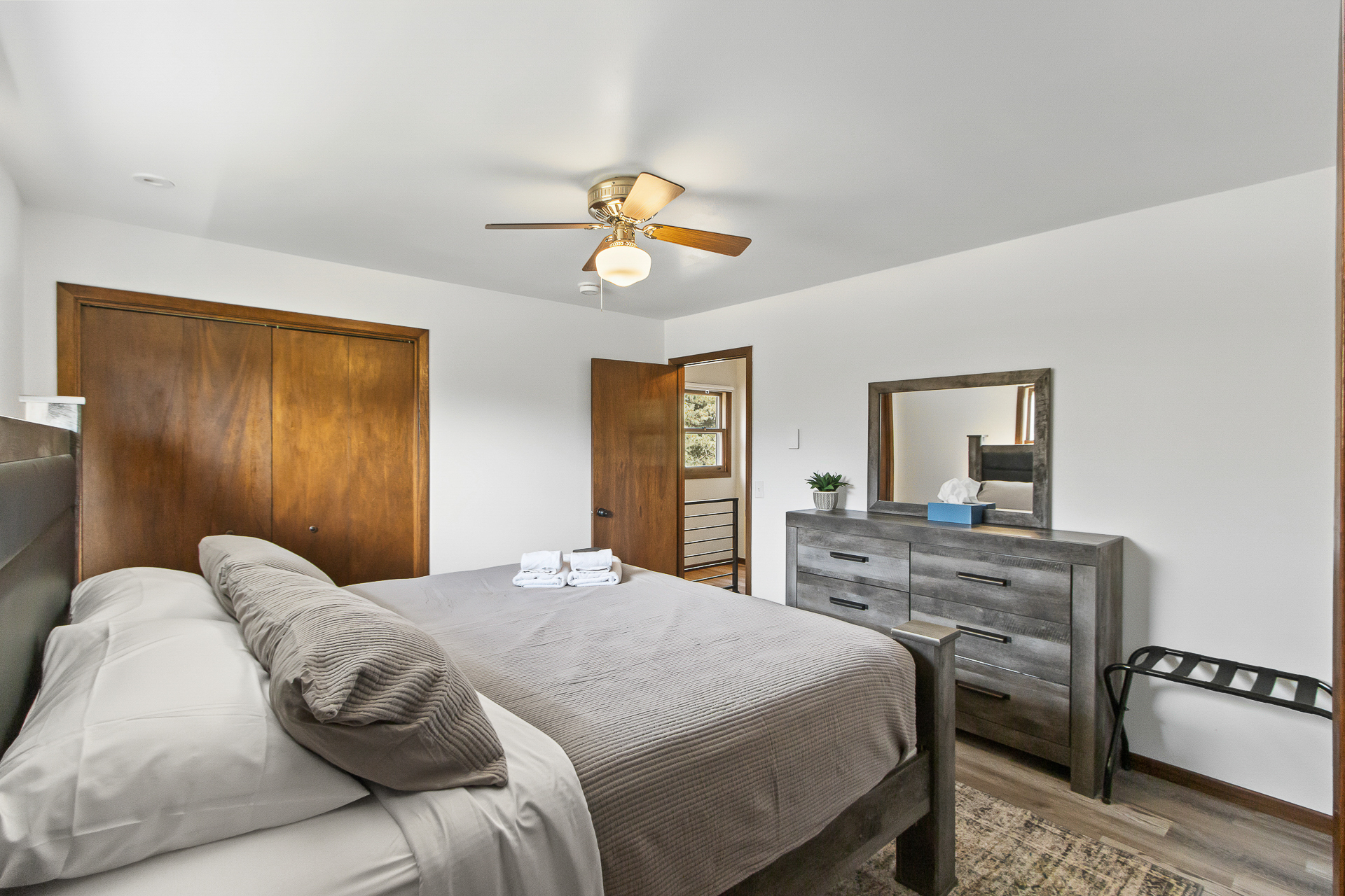 Bright, cozy bedroom with dresser, closet, and thoughtful guest touches