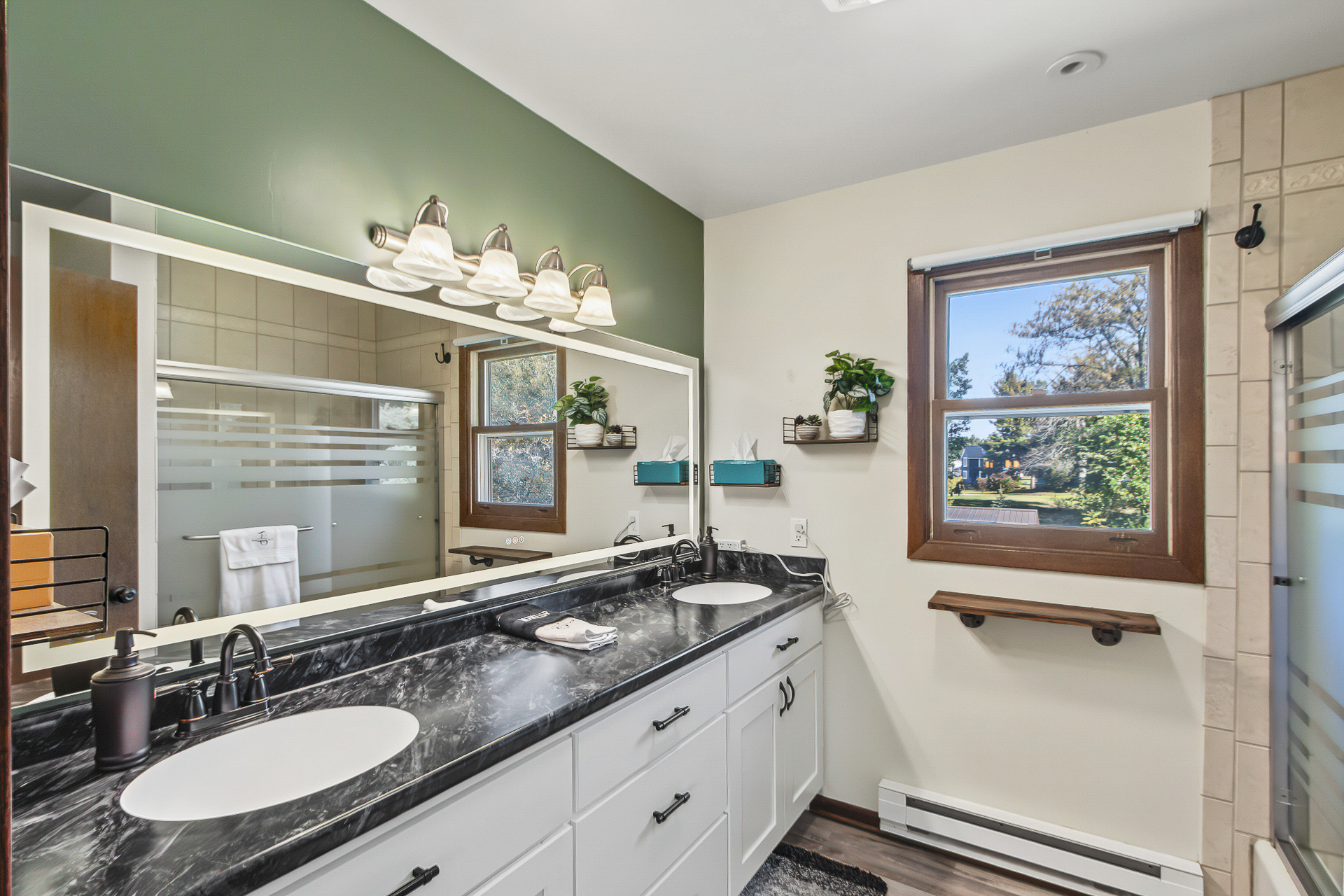 Bright bathroom with double vanity, large mirror, and stylish modern finishes