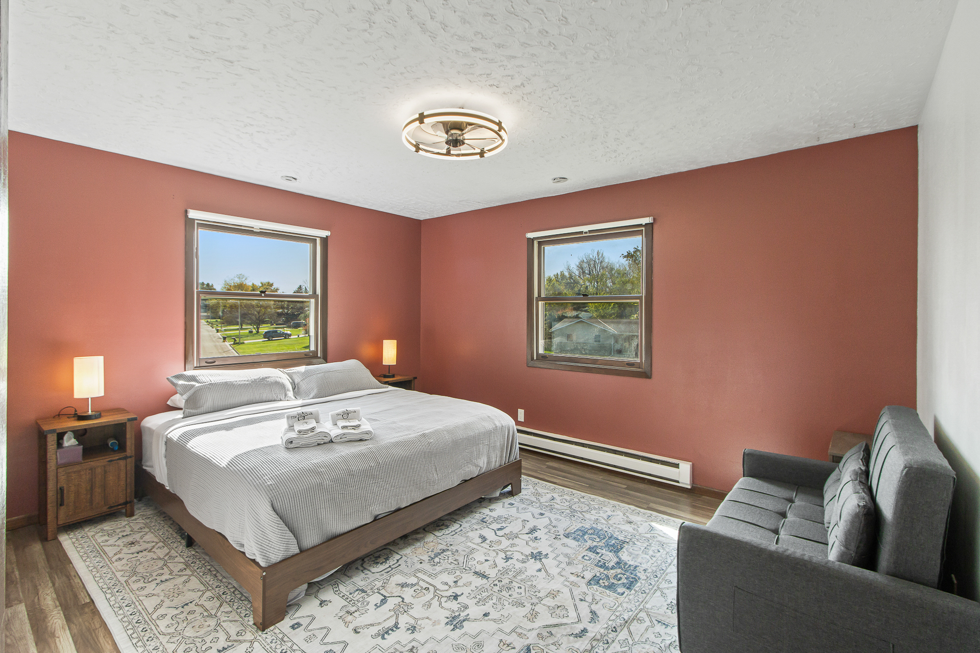 Bright king bedroom with cozy loveseat and warm, inviting style
