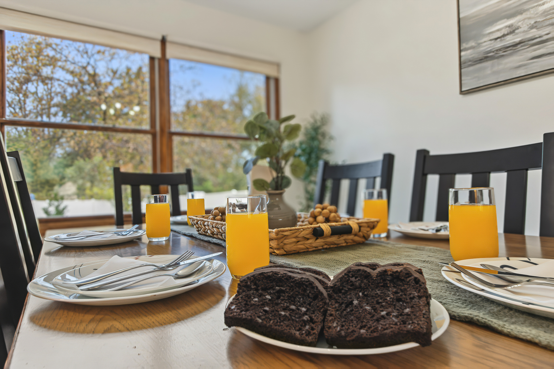 Sunny dining space with large windows and a welcoming breakfast setup