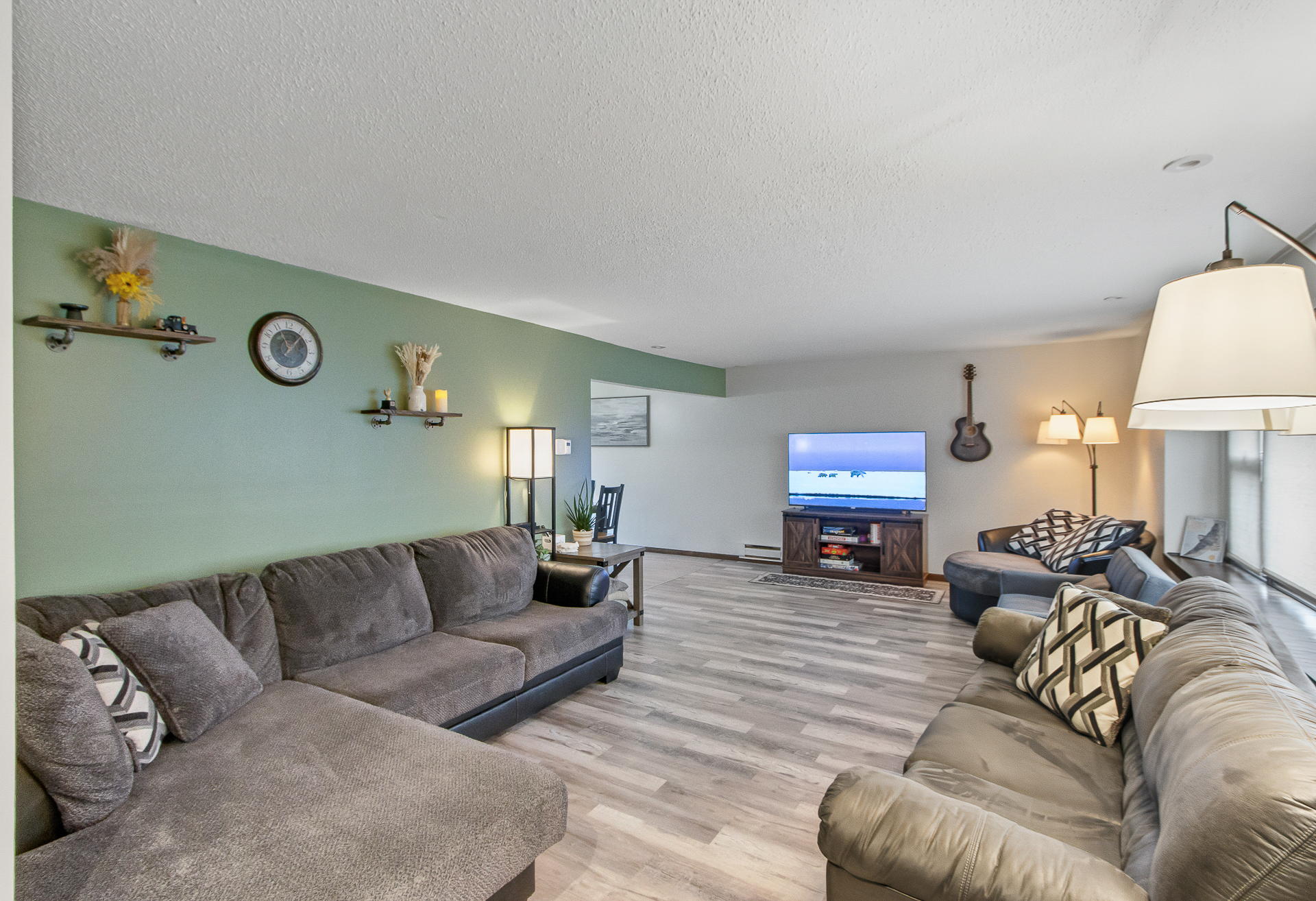 Spacious, bright living room with plenty of seating and a TV lounge area