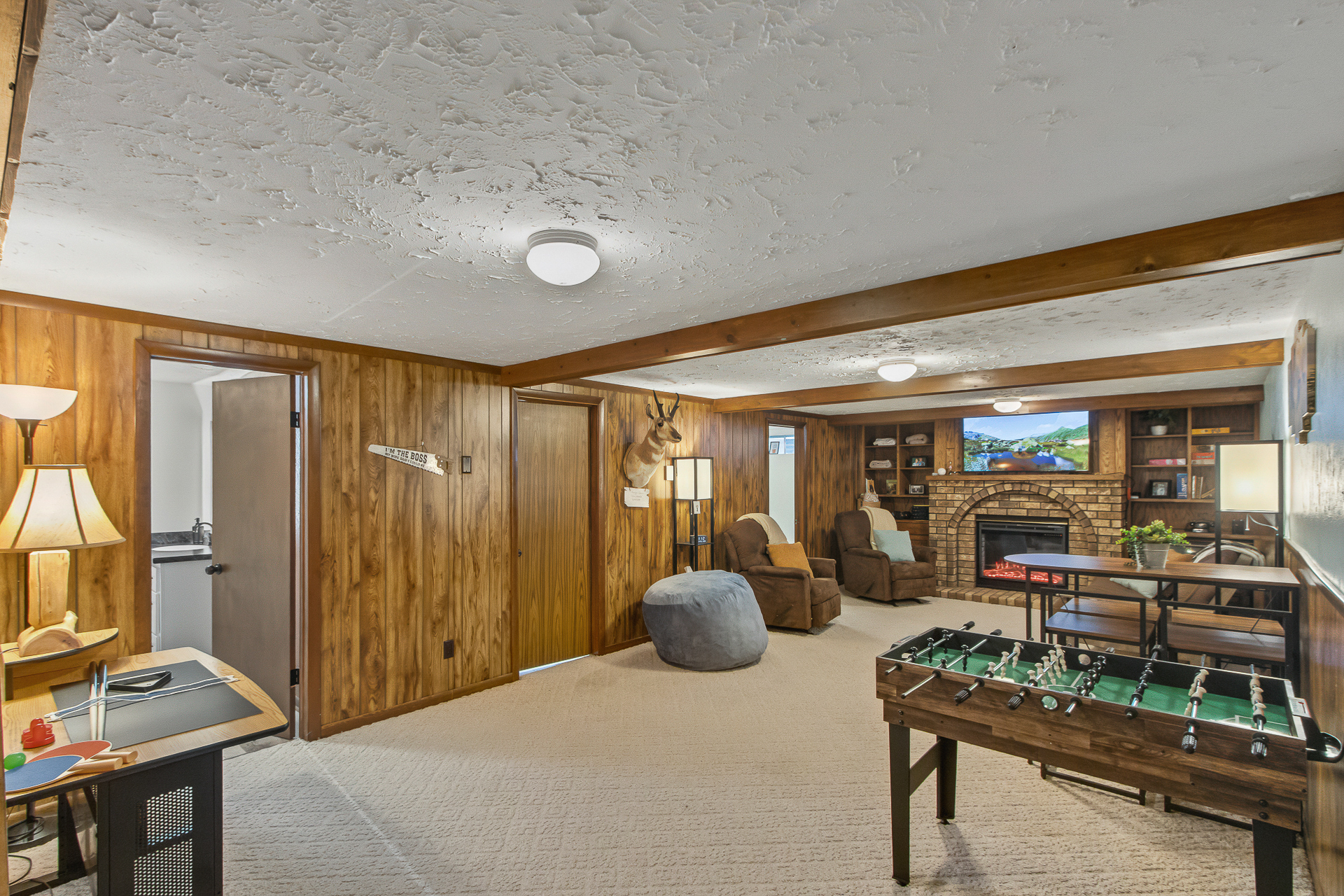 Cozy game room with fireplace, TV lounge, and foosball fun