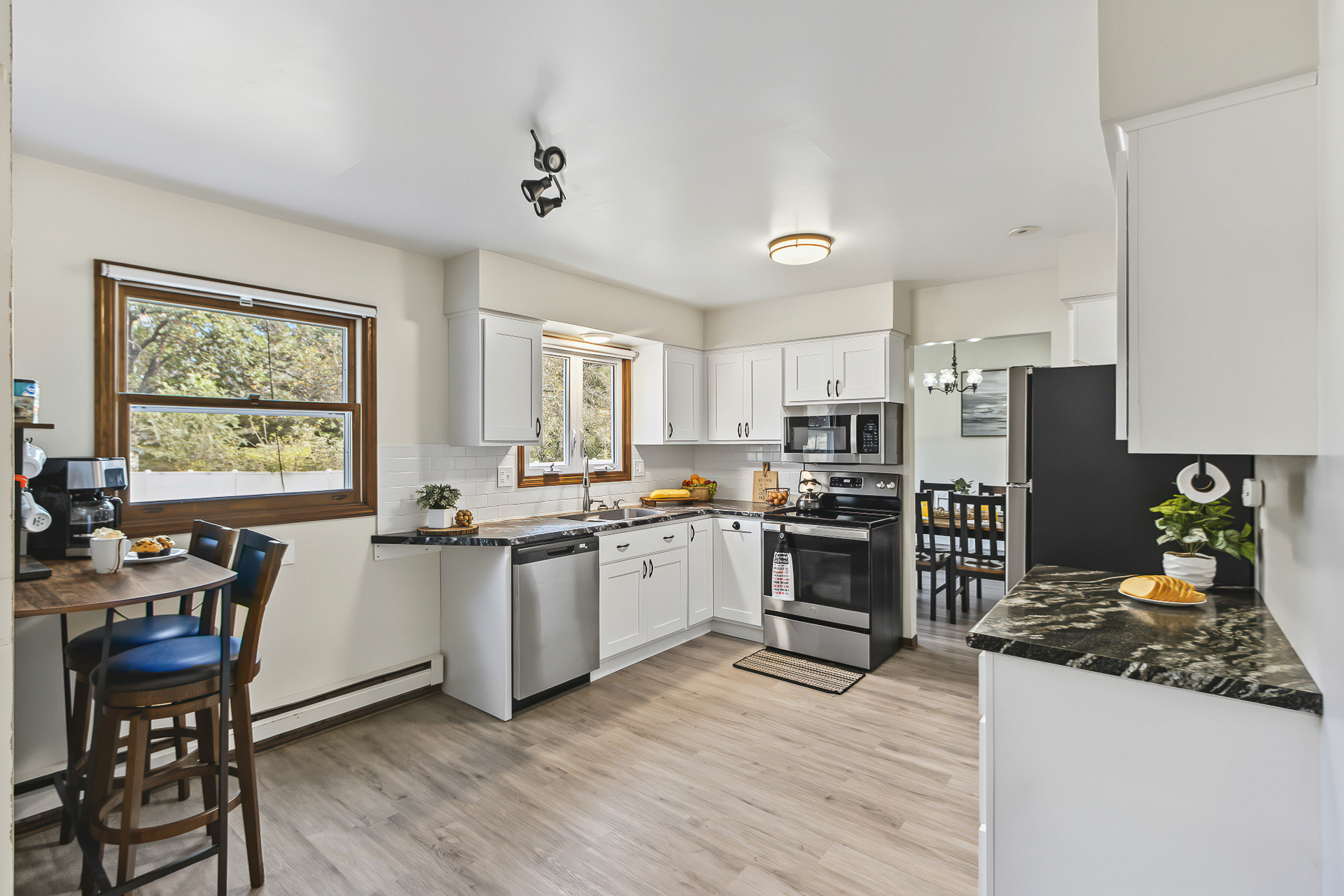 Bright modern kitchen with breakfast nook and sunny woodland views
