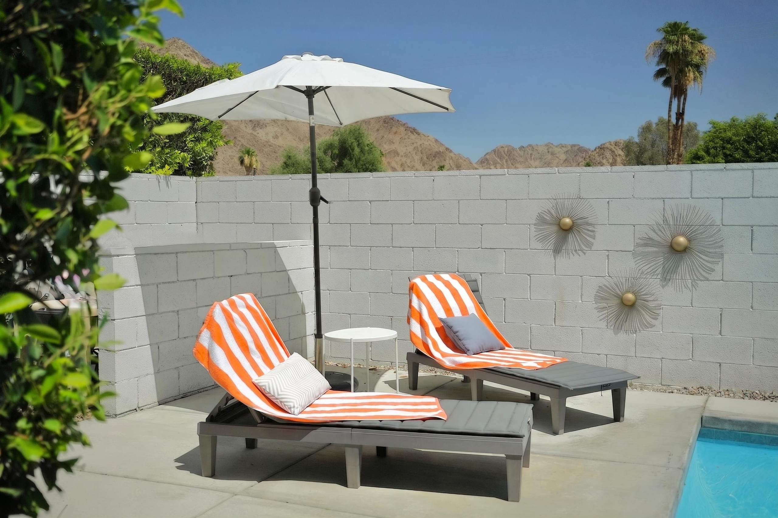 Private poolside loungers with mountain views and sunny desert style