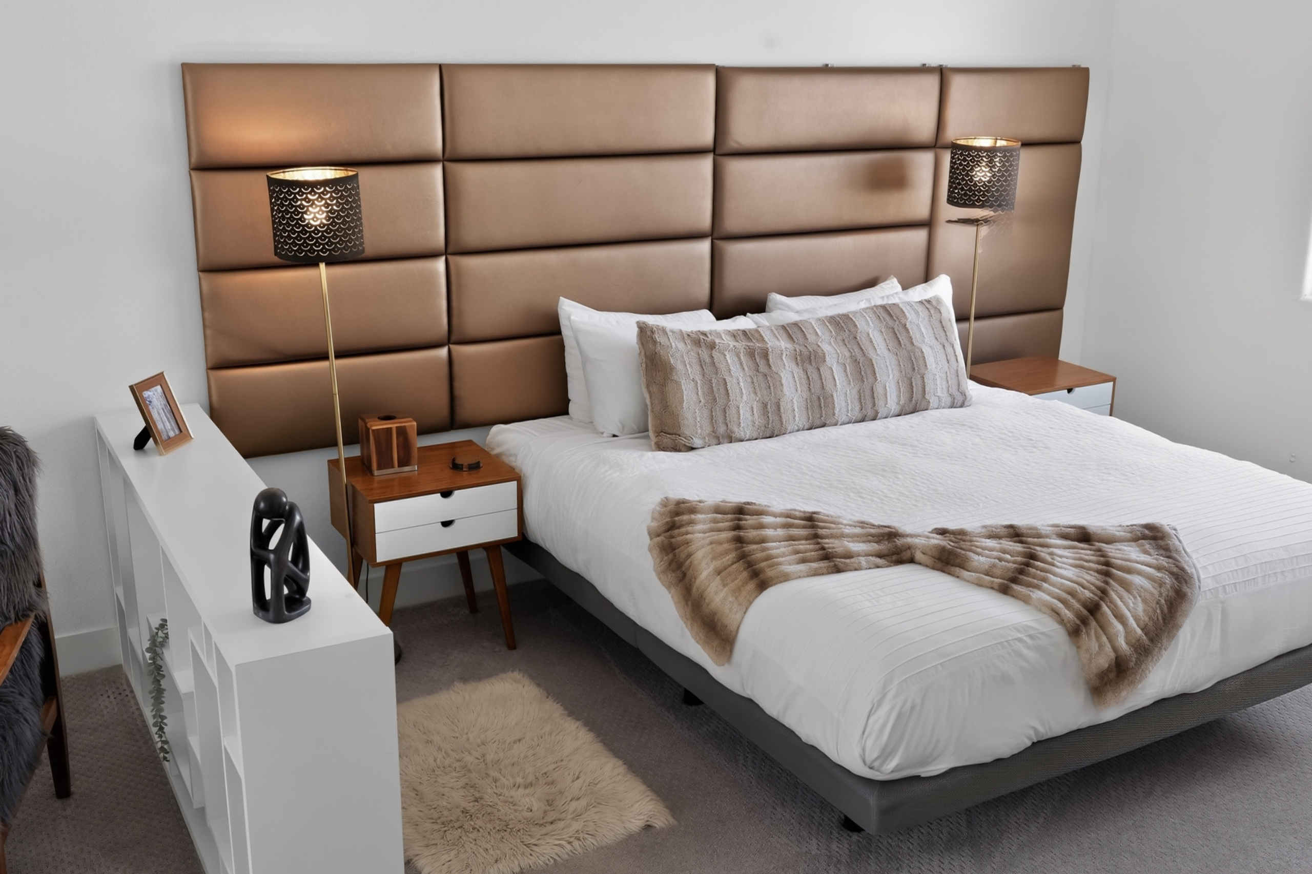Elegant modern bedroom with statement headboard and cozy hotel-style bed