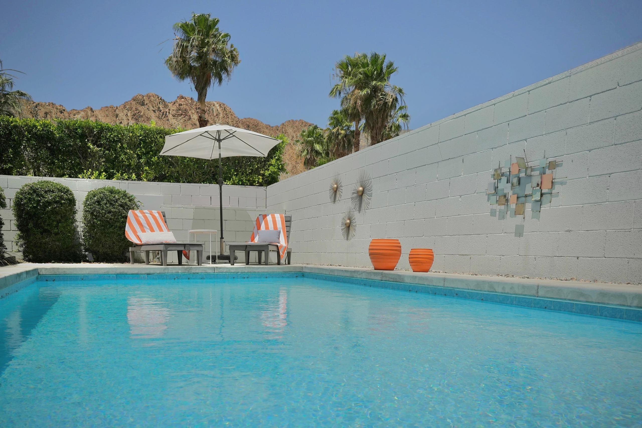 Private pool with mountain views, loungers, and sunny desert ambiance