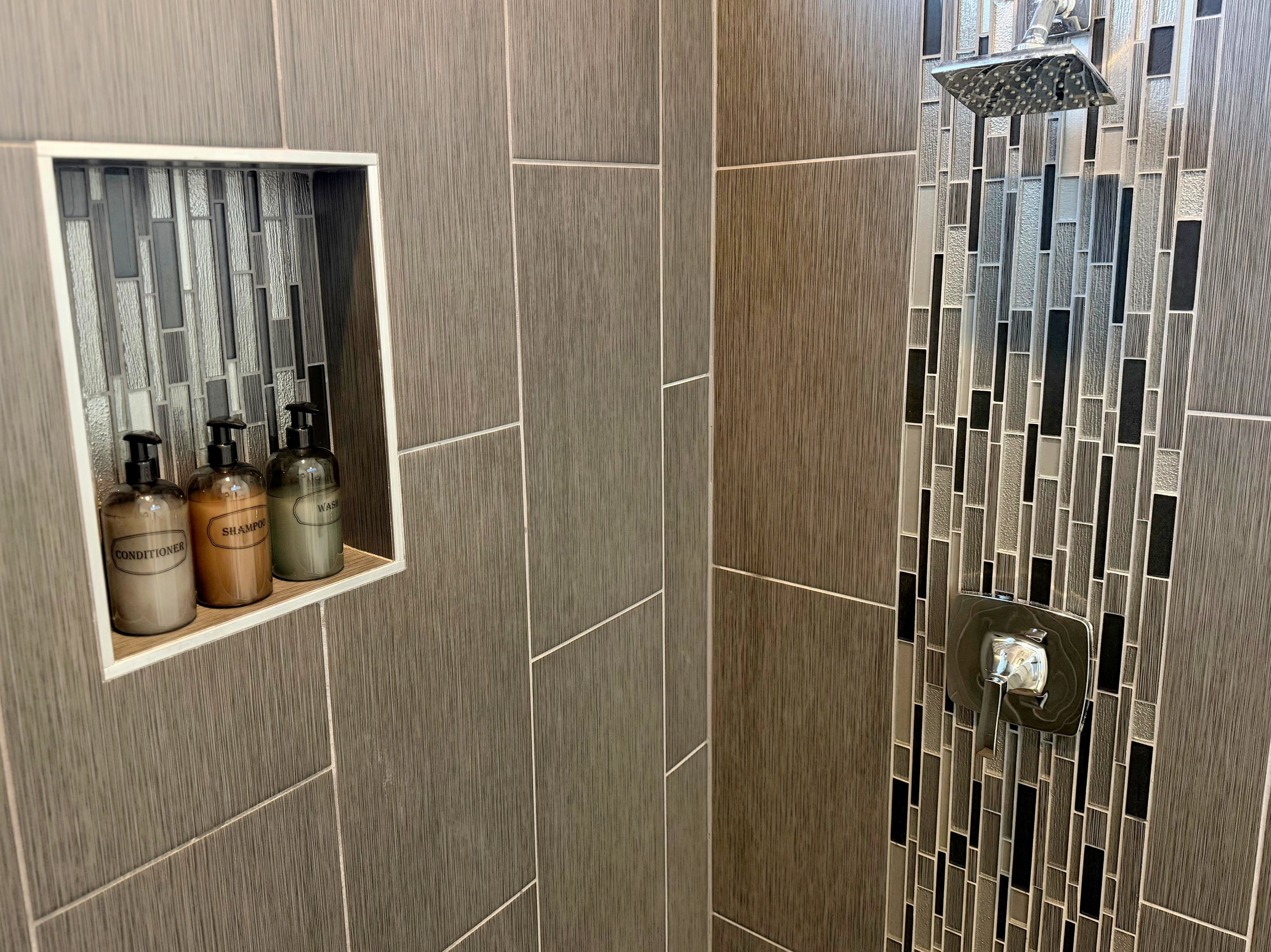 Modern tiled walk-in shower with rainfall head and built-in niche