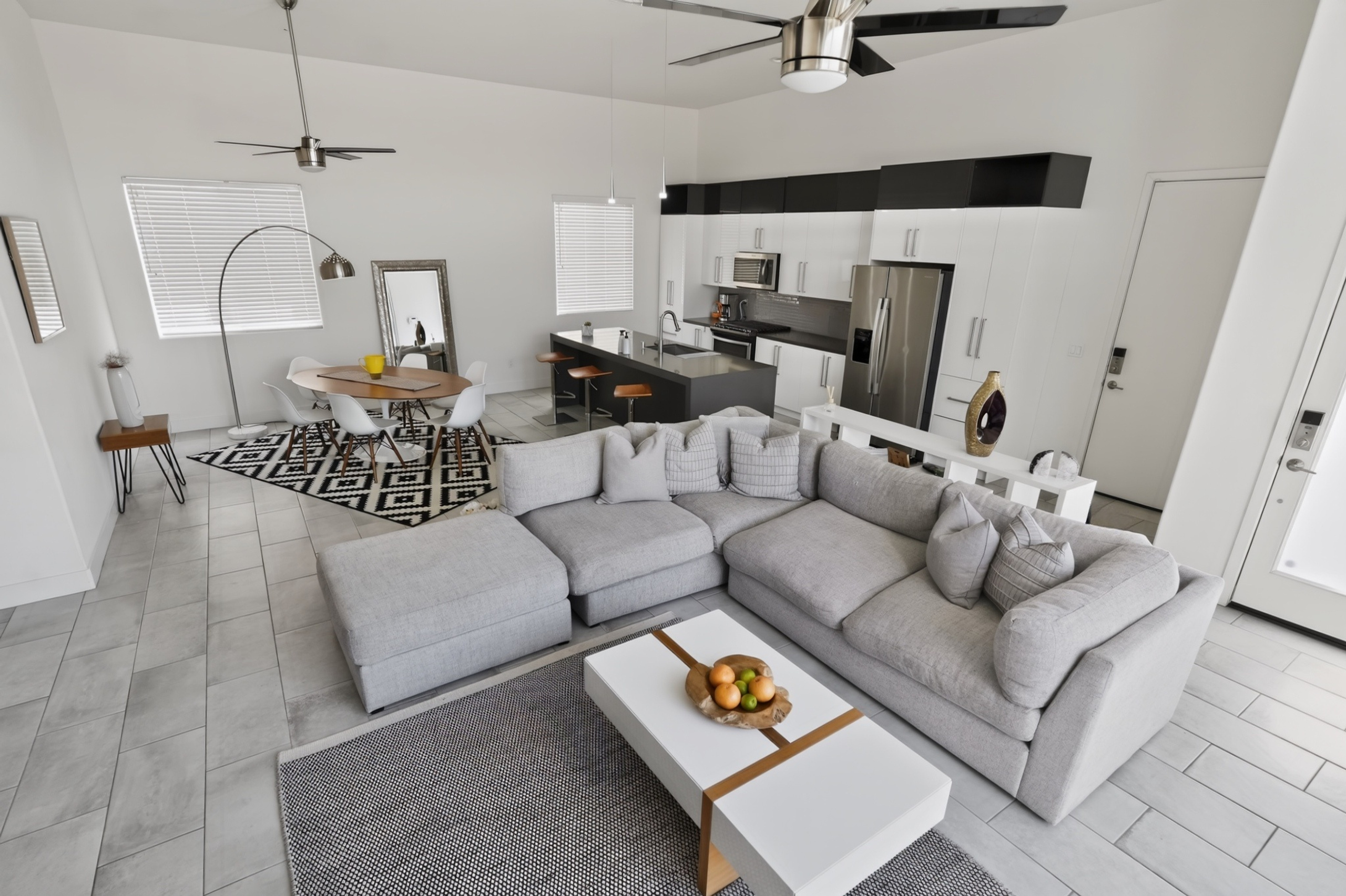 Bright open-concept living with large sectional and sleek modern kitchen