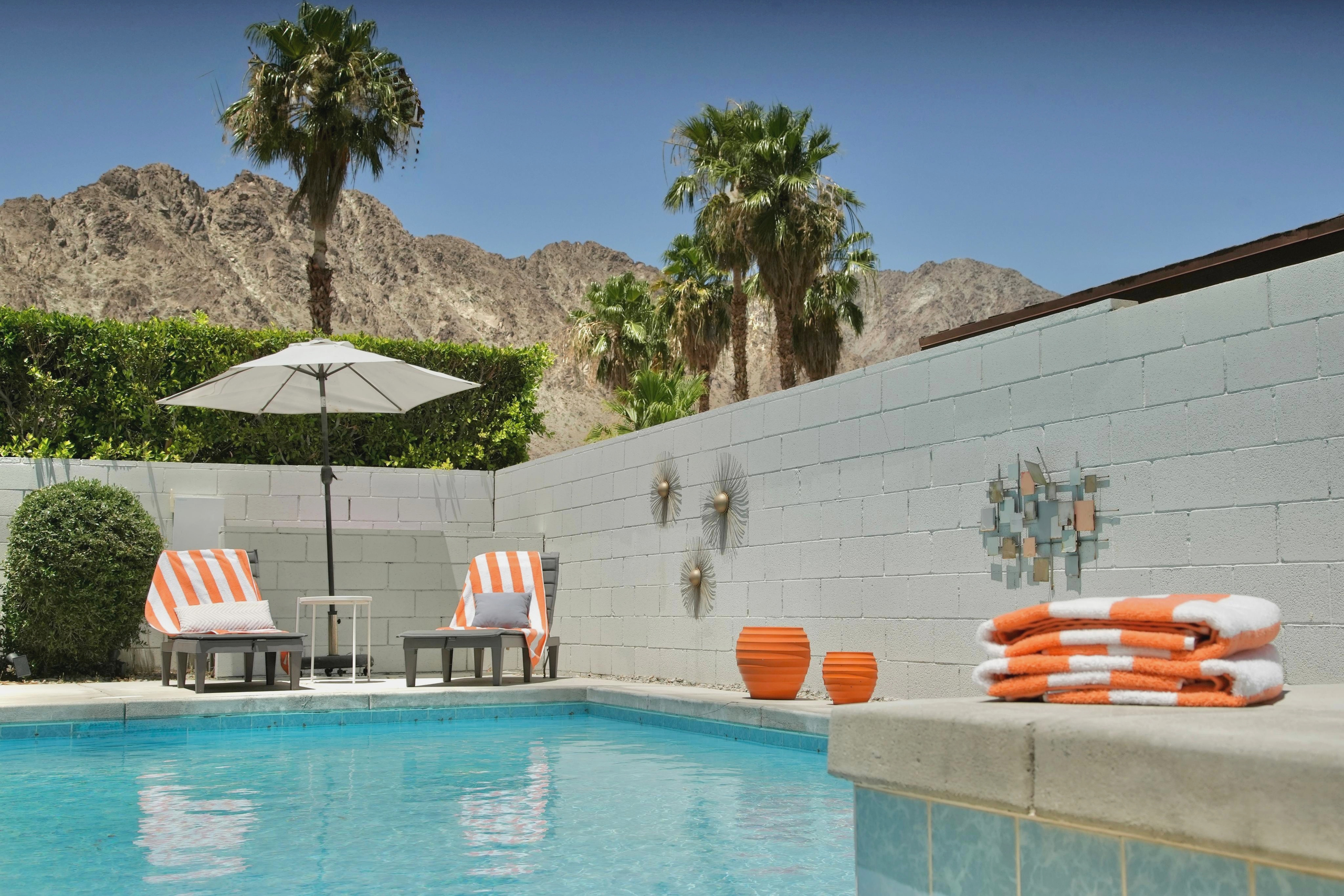 Private pool with loungers, palm trees, and stunning mountain views