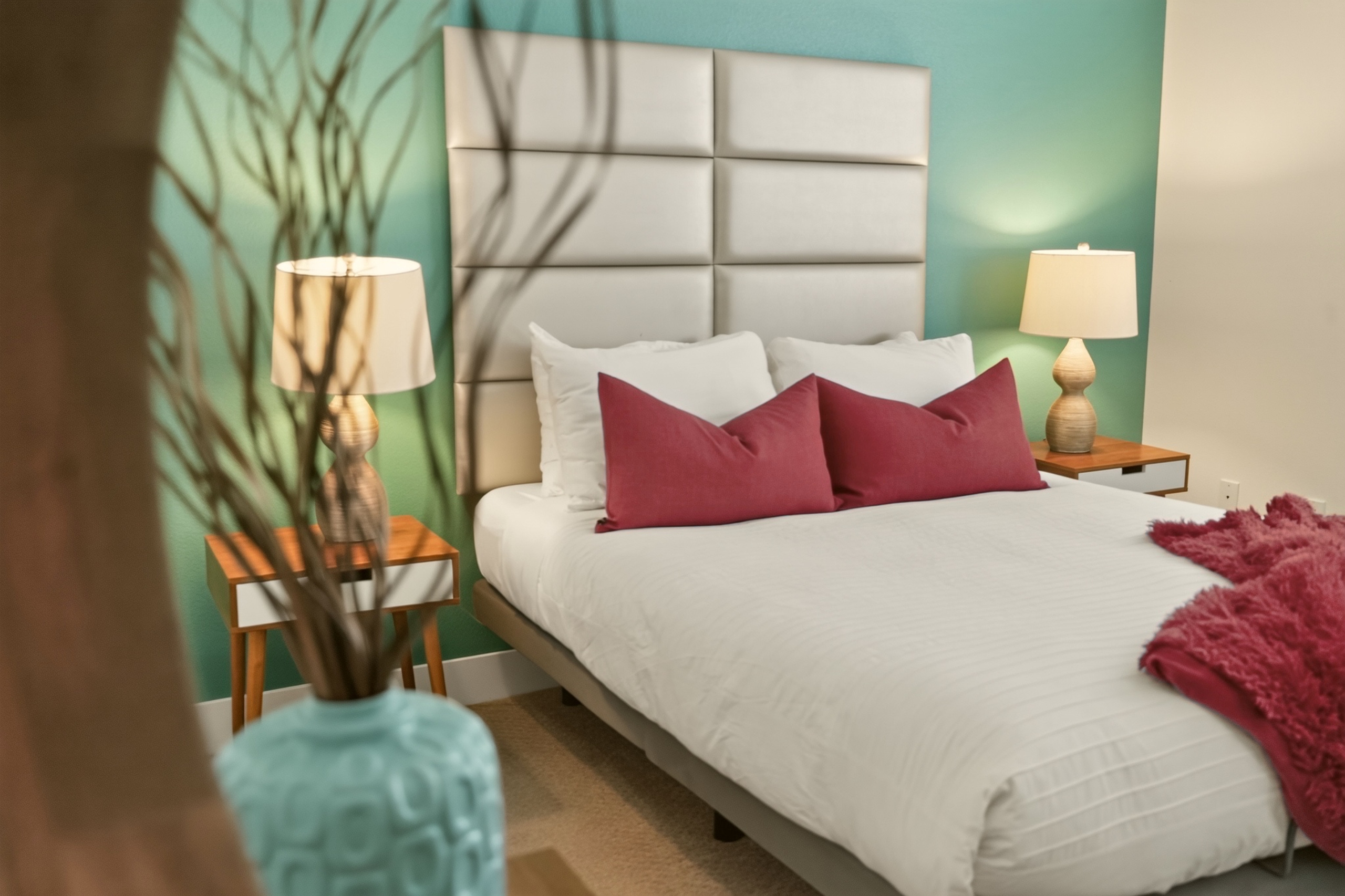 Stylish bedroom retreat with teal accent wall and cozy designer touches