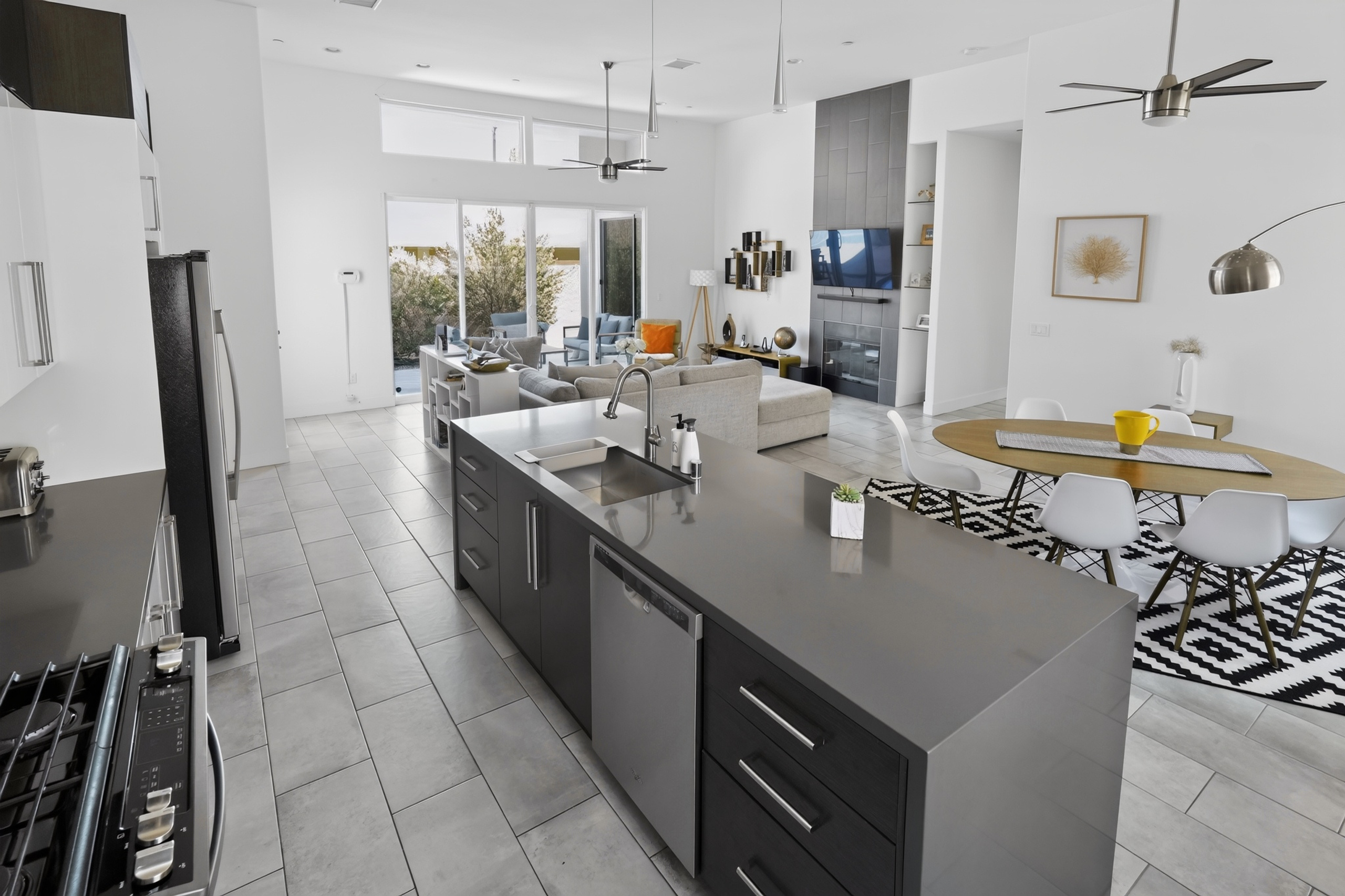 Bright open-concept living with sleek kitchen, high ceilings, and patio access