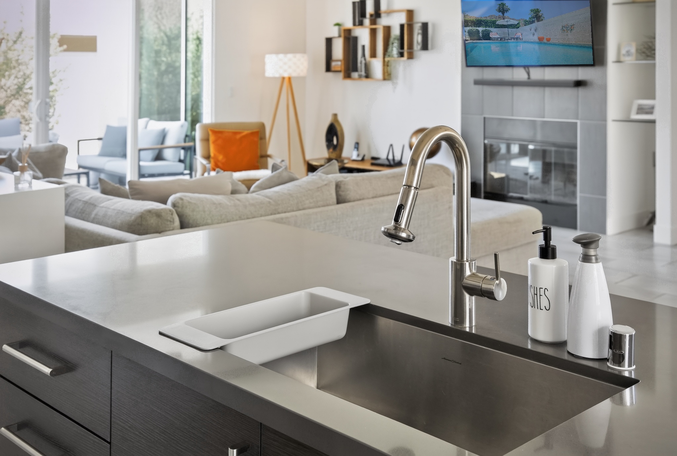 Bright modern kitchen opens to a stylish lounge with fireplace and TV