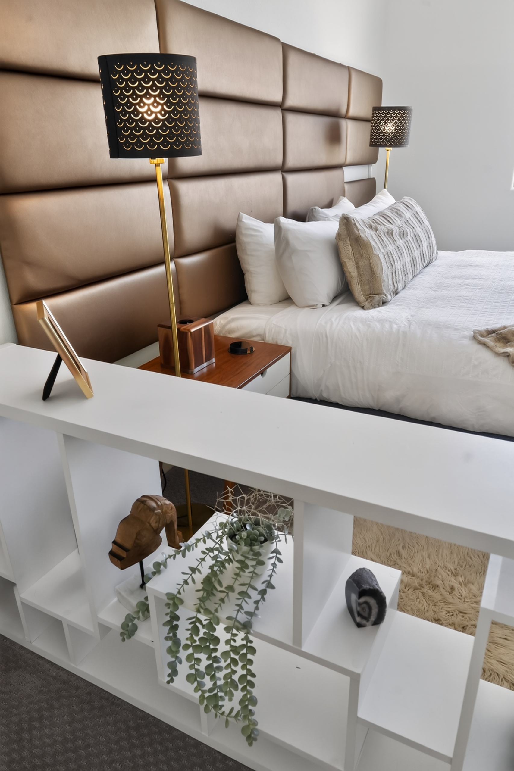 Elegant bedroom with luxe headboard, cozy lighting, and modern decor