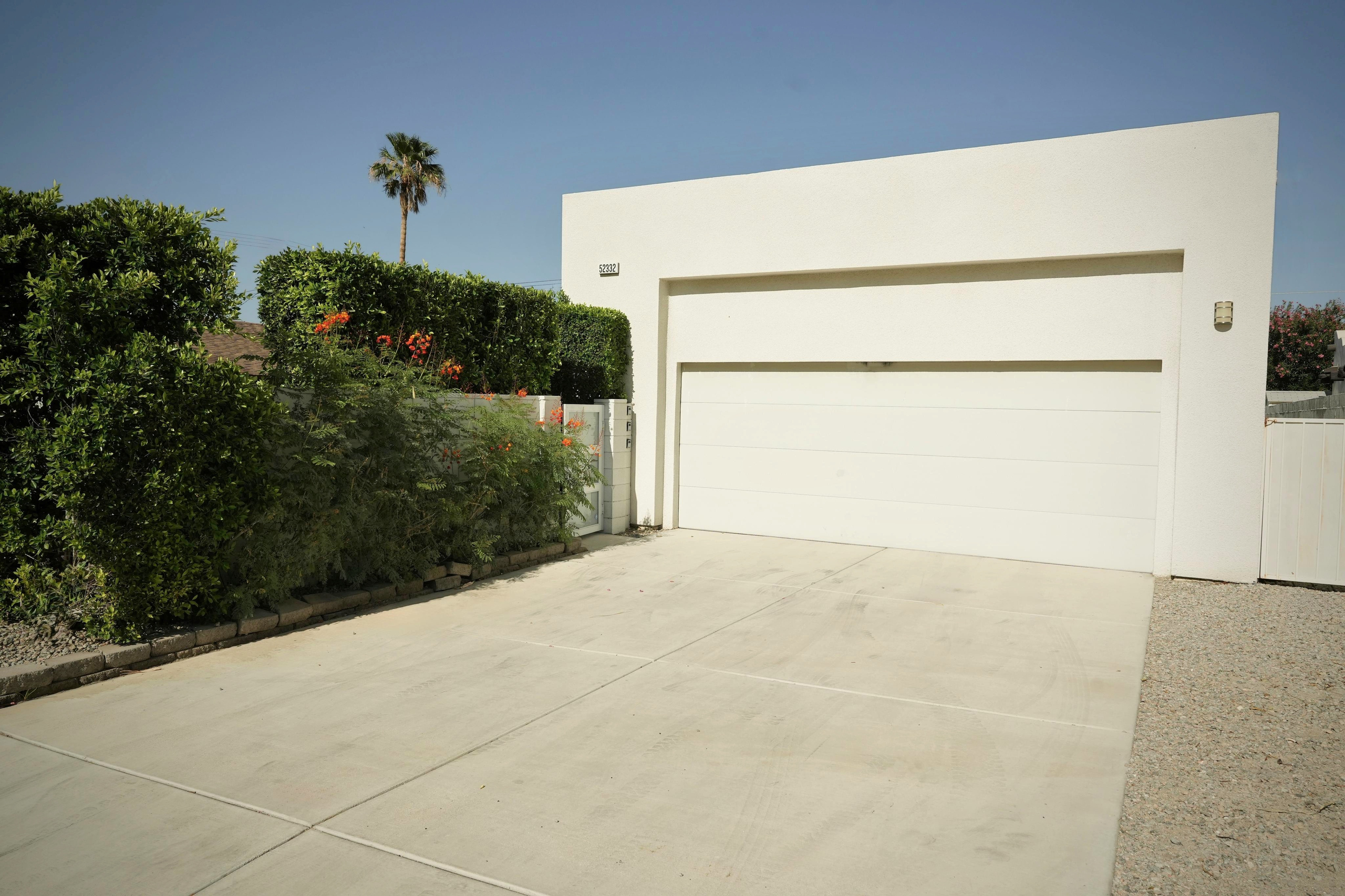 Spacious private driveway with modern two-car garage and lush landscaping