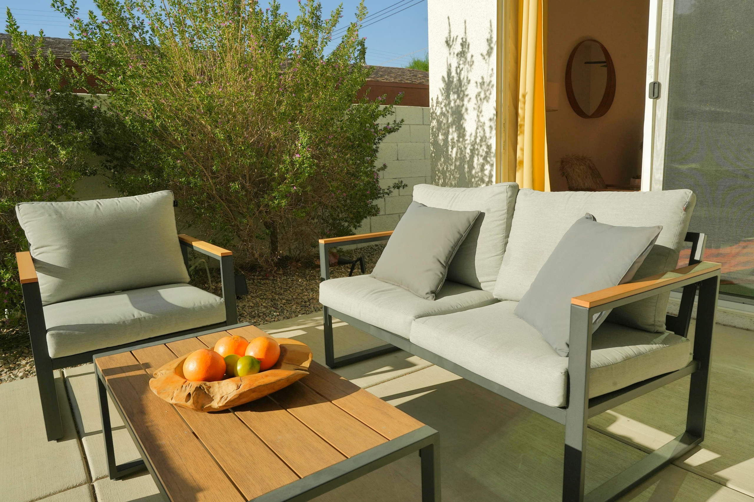 Sunny private patio with stylish lounge seating and garden views