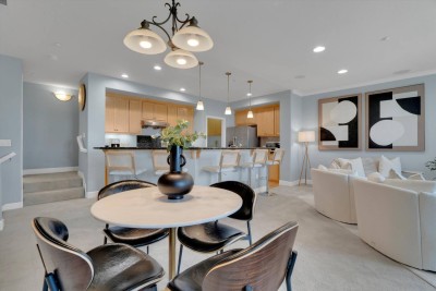 Stylish Dining Nook! ️ Enjoy meals at the chic circular dining table with seating for four, perfectly positioned near the kitchen. Features modern black chairs and a striking chandelier. 