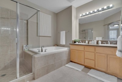 Spacious Full Bathroom!  Indulge in this generous bathroom featuring a large soaking tub and a separate glass-enclosed walk-in shower. A double vanity with plenty of counter space and bright lighting ensures comfort for all guests. 