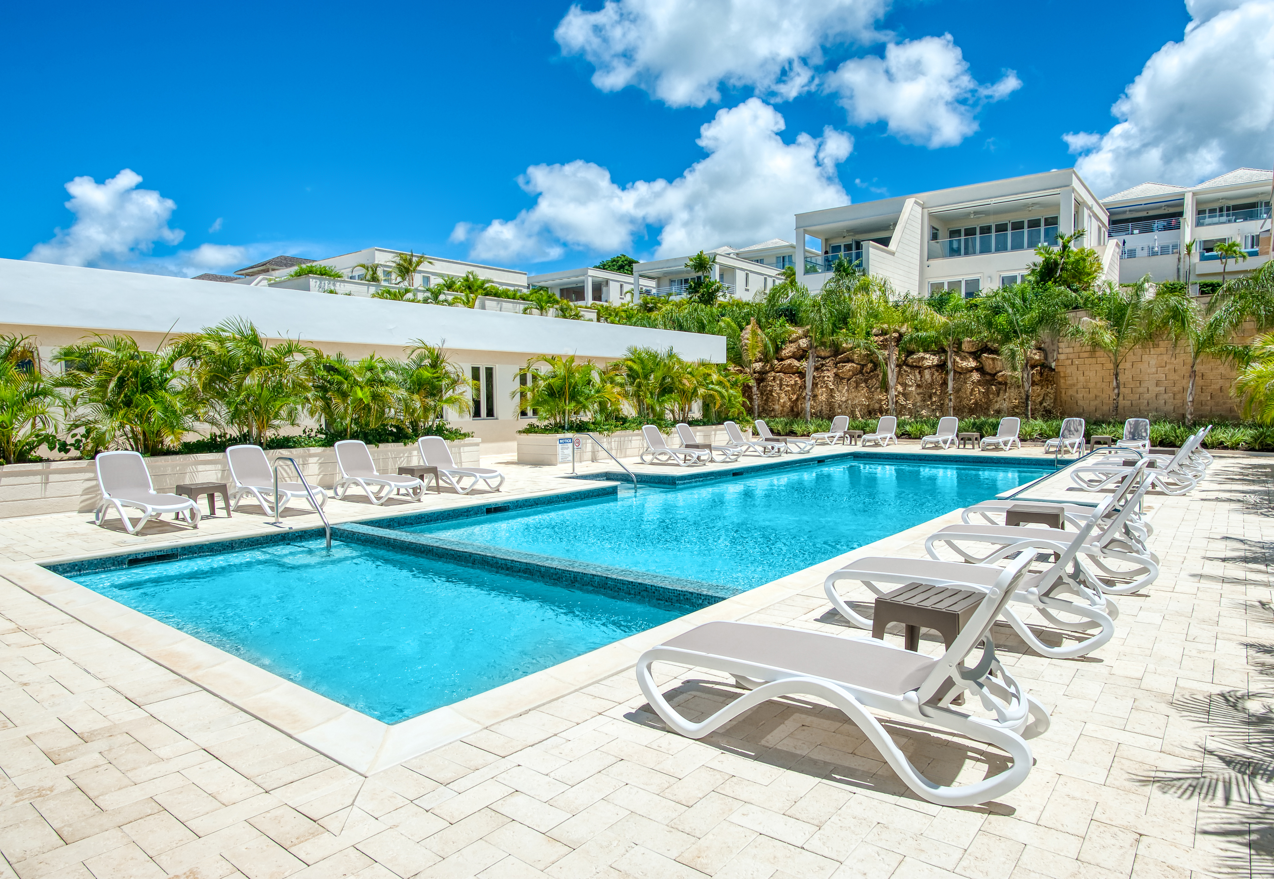 Resort-style pool with tropical landscaping and ample lounge seating