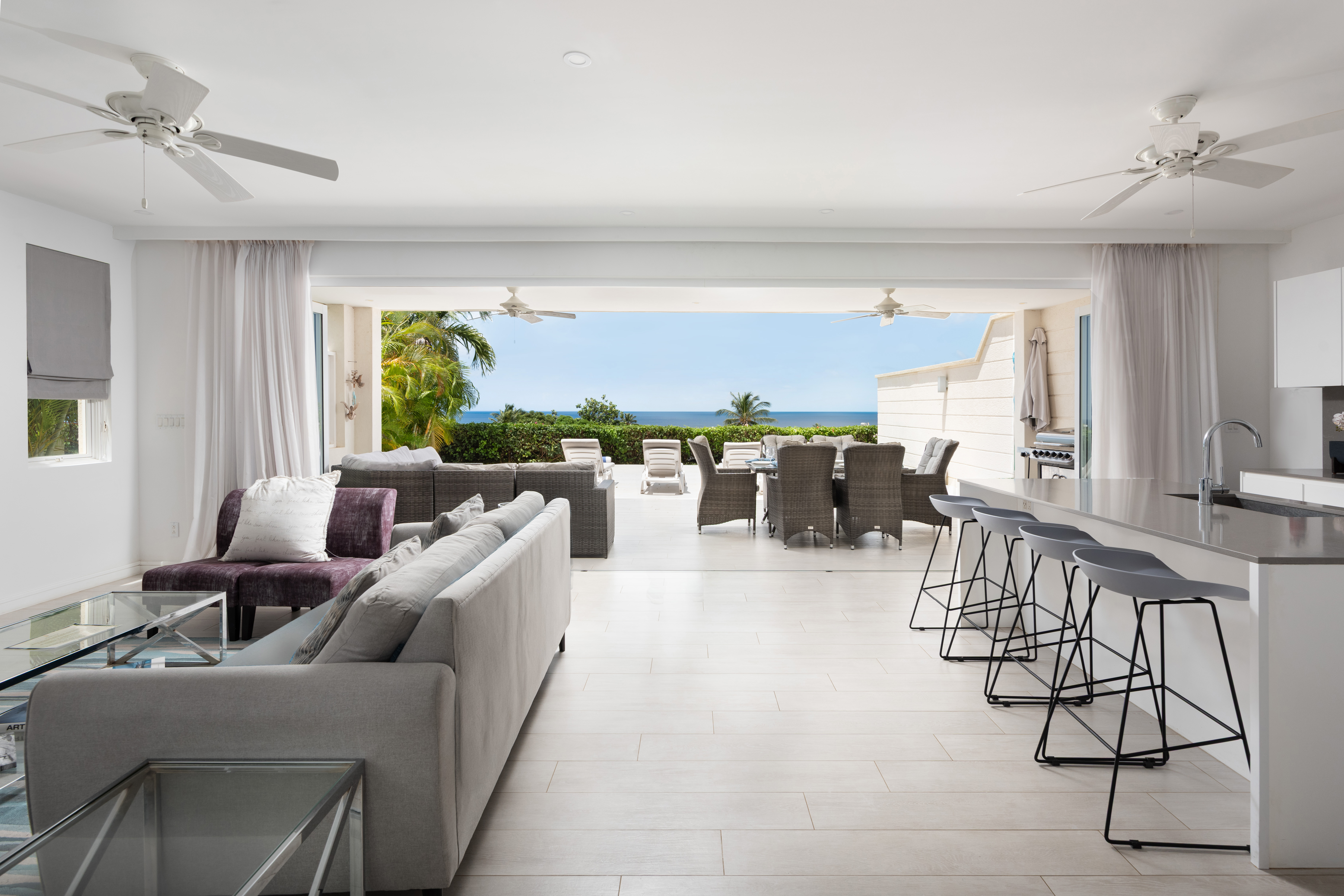 Bright open-plan living with ocean-view terrace and stylish outdoor dining