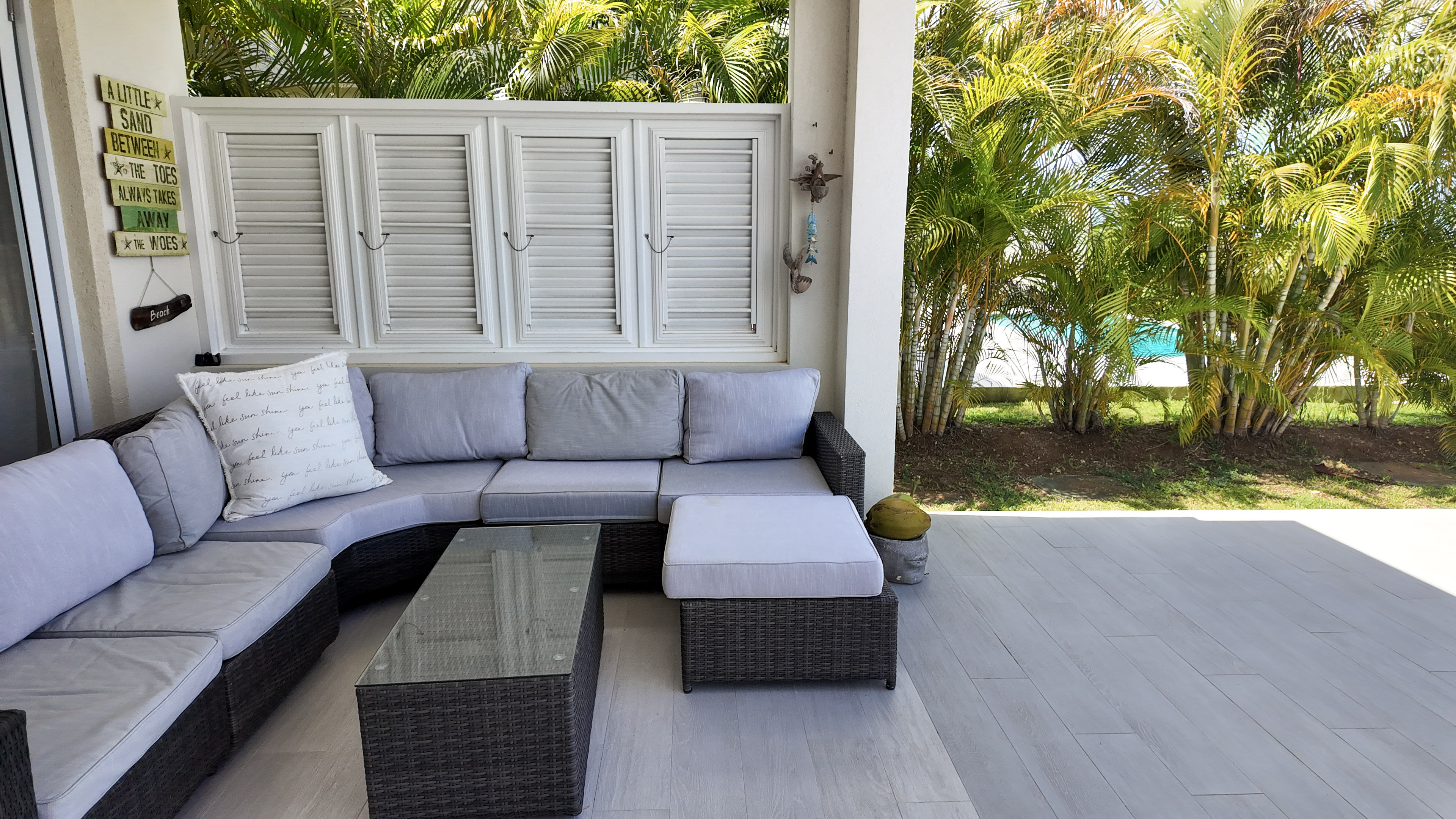 Covered tropical patio with cozy sectional seating by the pool