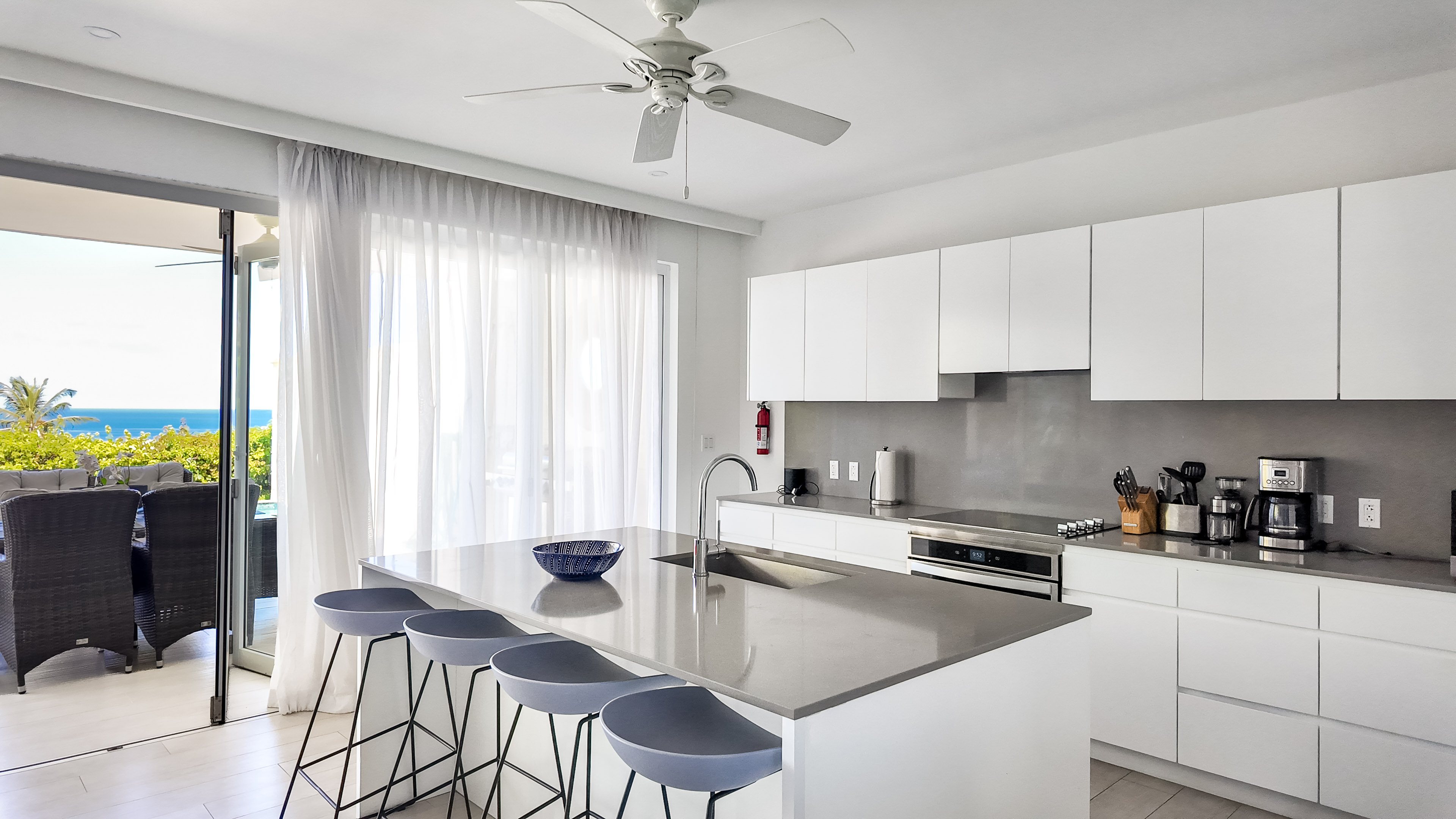 Bright modern kitchen with island seating and stunning ocean-view patio