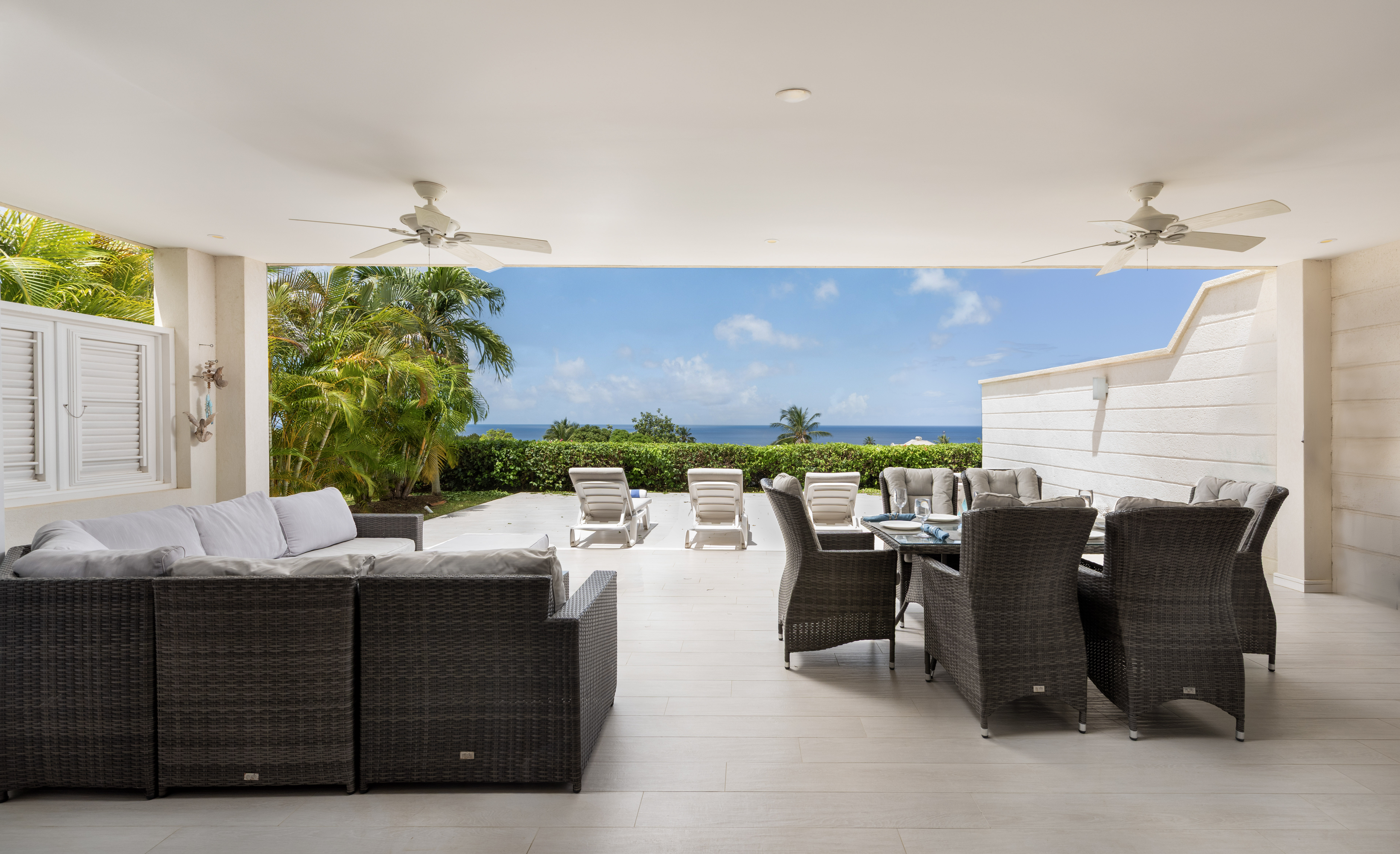 Covered ocean-view patio with outdoor dining and tropical lounge space