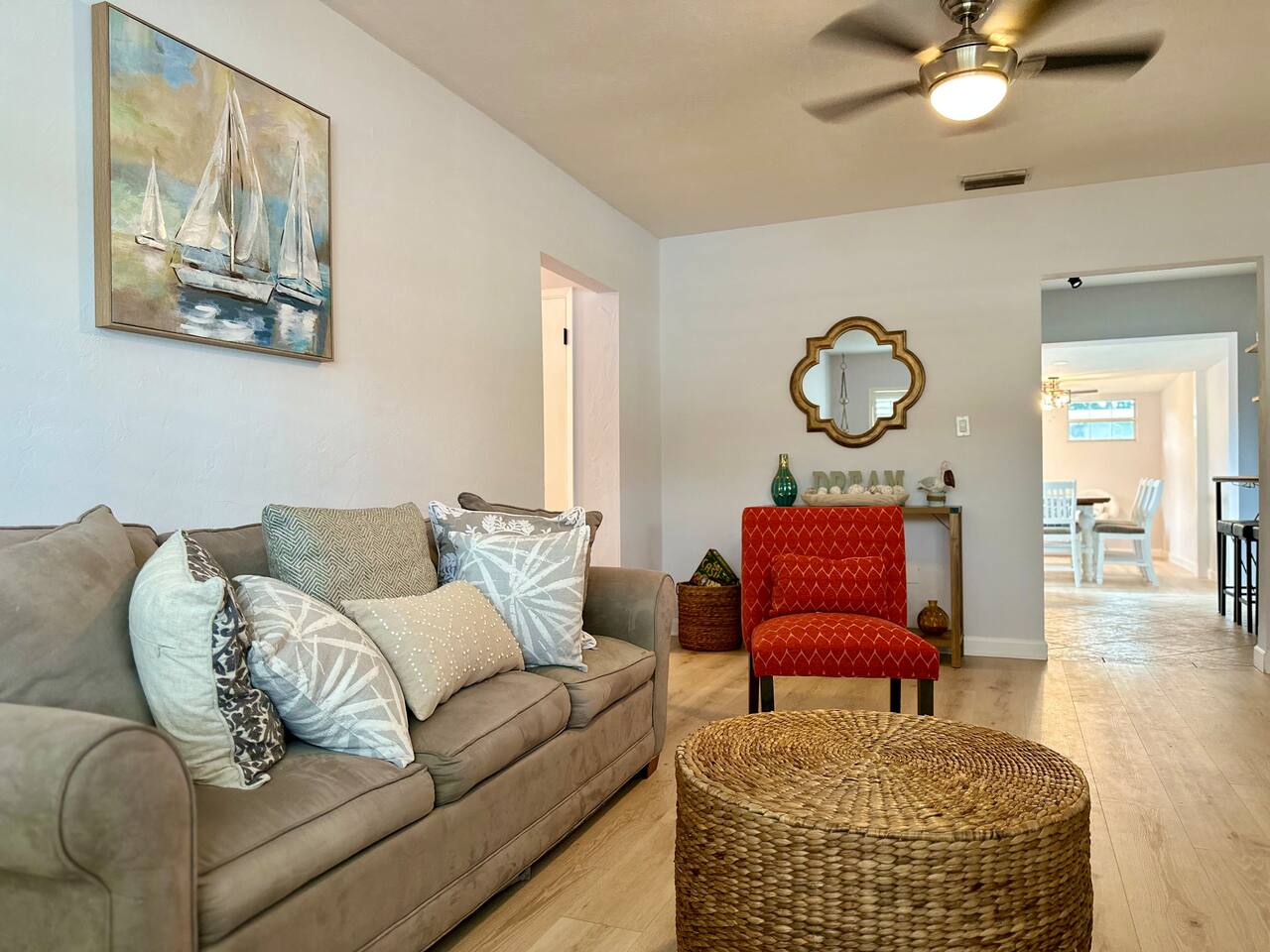 Bright living room with gray sofa and red accent chairs