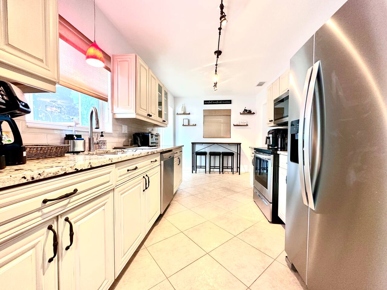 Long renovated kitchen with stainless appliances