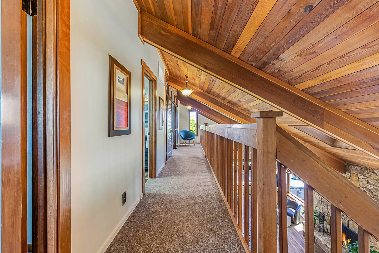 Step into the loft hall, where natural light and open space create a welcoming atmosphere. This versatile area is perfect for relaxing, reading, or enjoying a moment of calm with stunning views just beyond. 