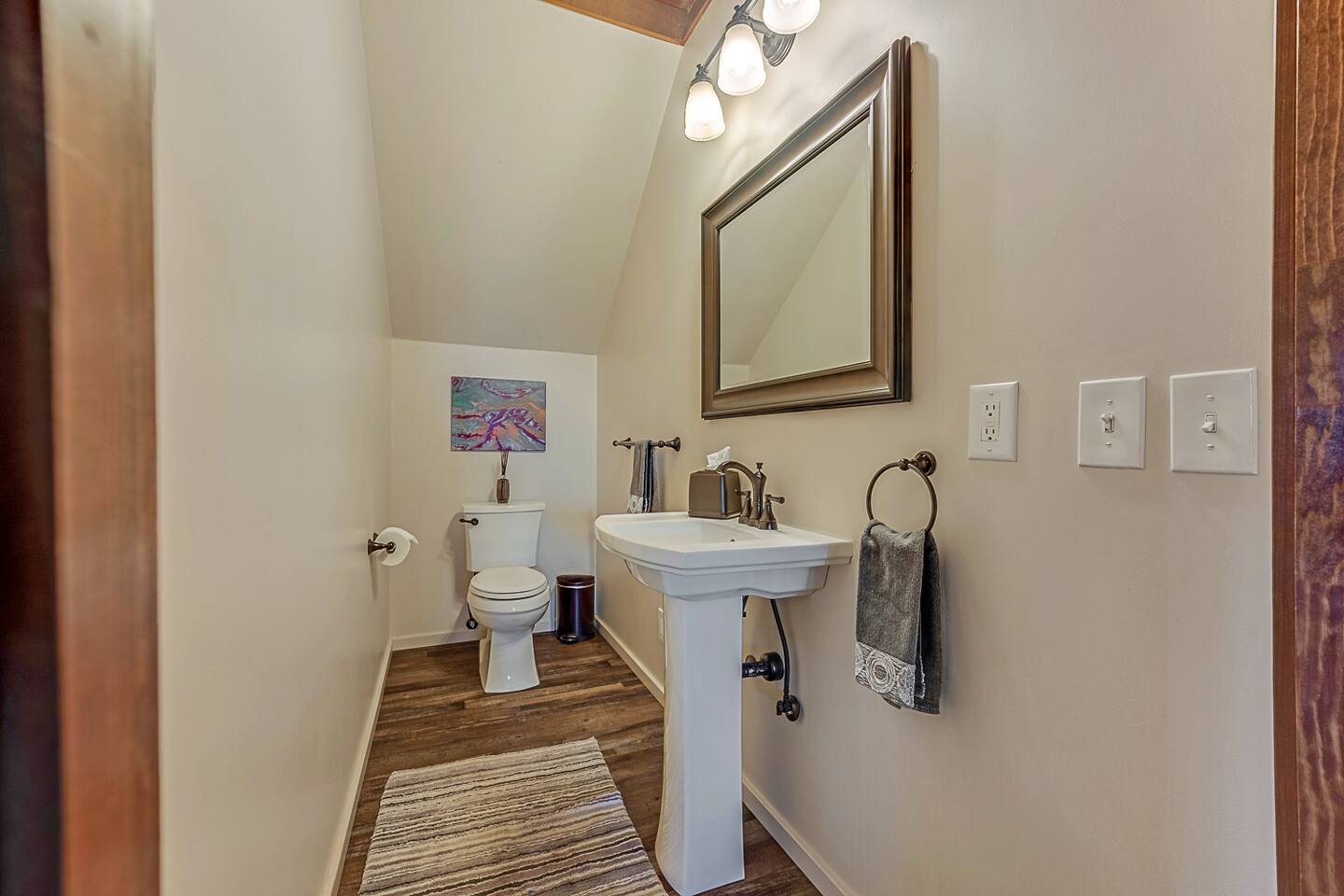 Conveniently located on the first floor beneath the stairs, this stylish half bath offers a perfect blend of function and charm. A thoughtful addition for easy access and comfort during your stay.