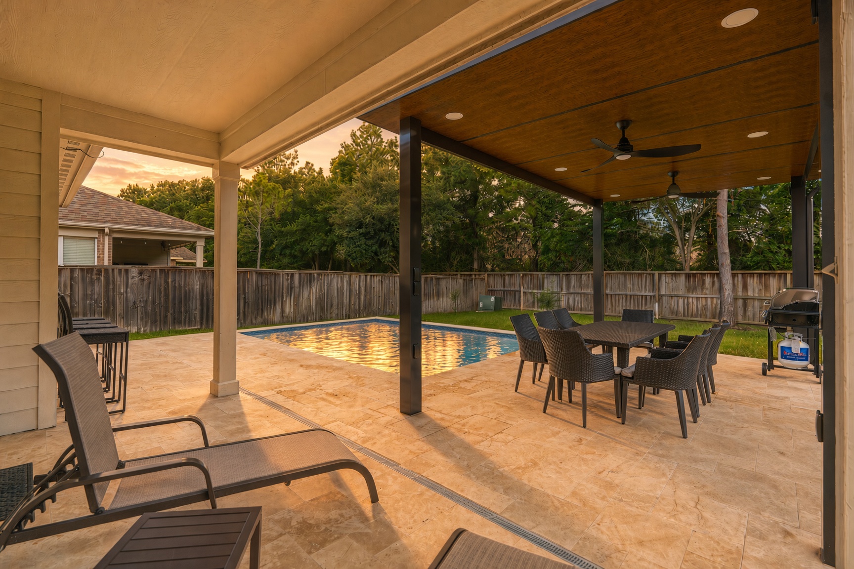 Private pool patio with covered dining, loungers, and grill