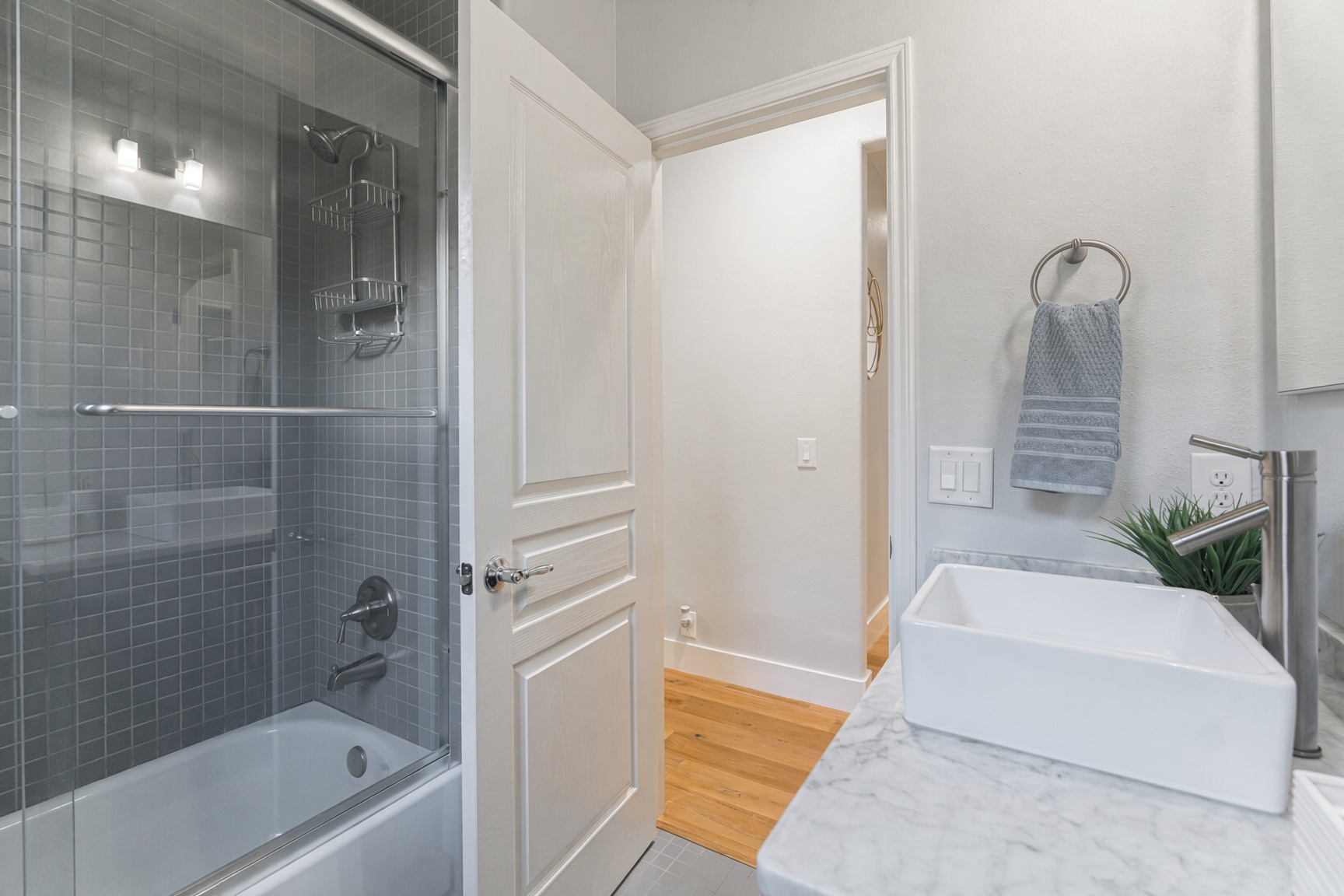 Bright modern bath with glass shower, vessel sink, and sleek finishes