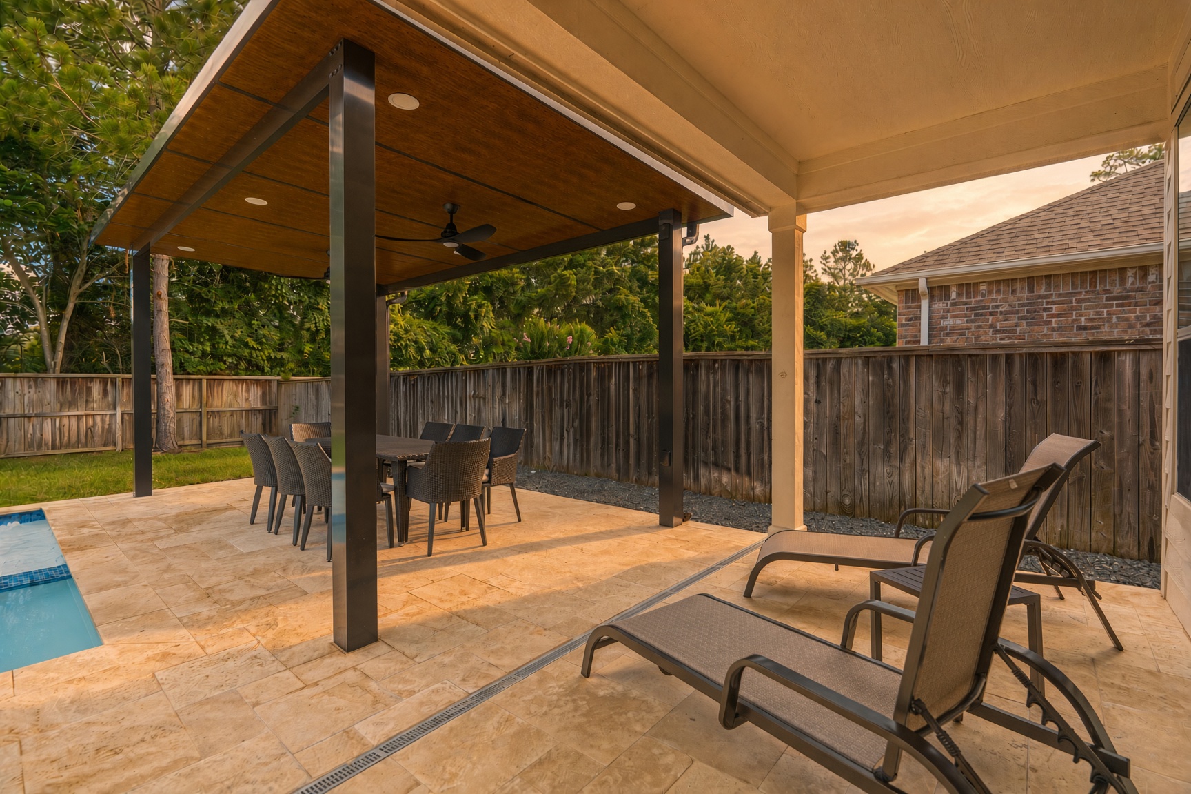Covered poolside patio with dining area and relaxing lounge chairs