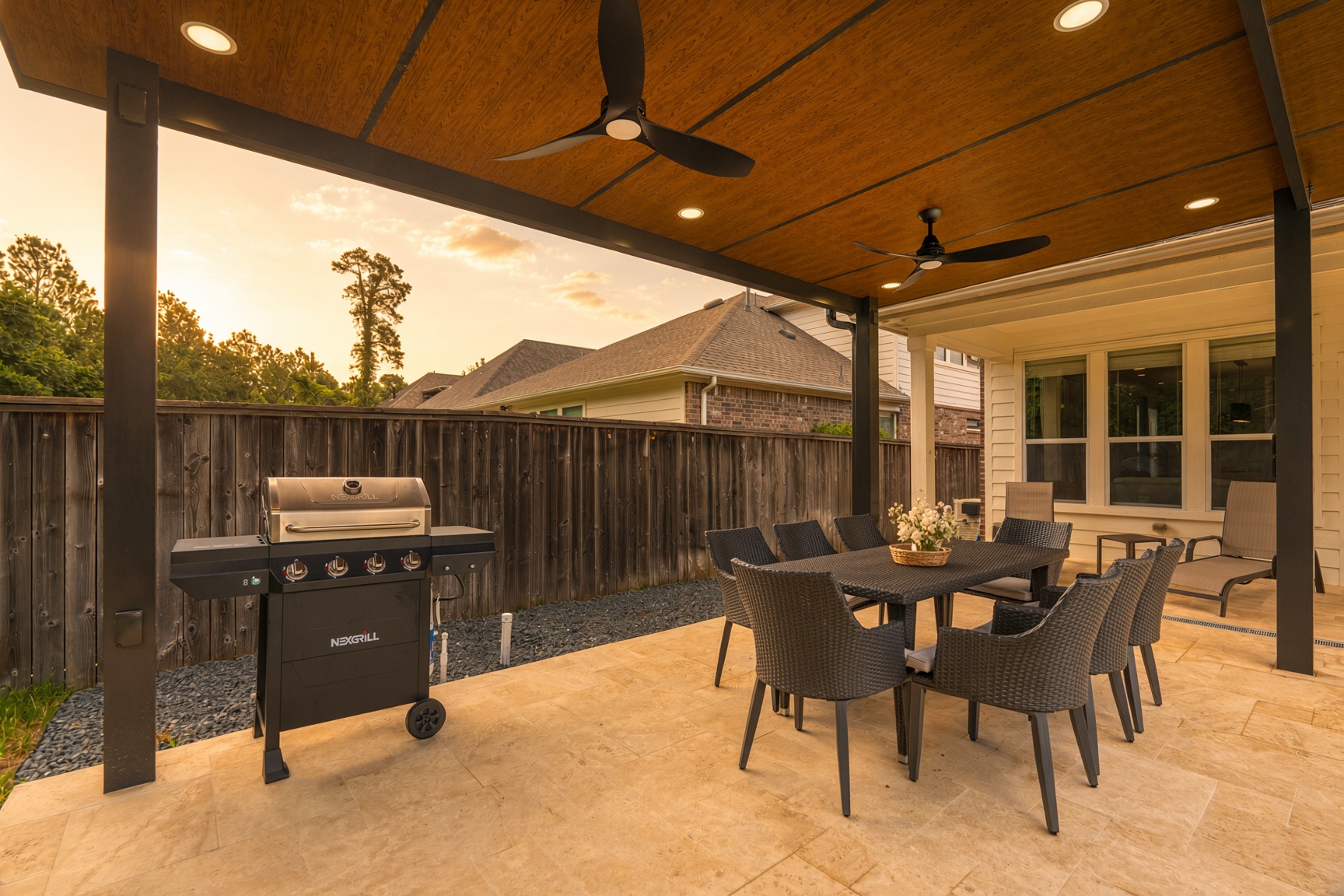Covered patio with dining area, grill, and ceiling fans for relaxing outdoors