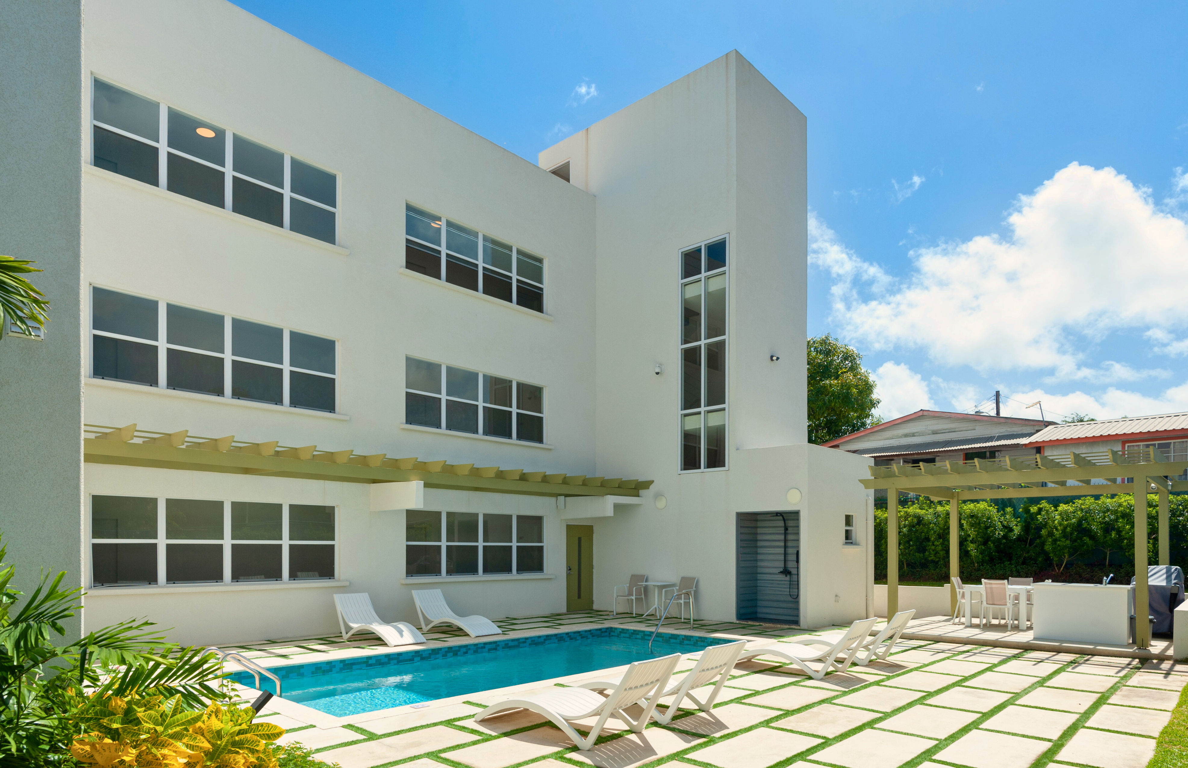 Modern home with private pool, loungers, and stylish outdoor dining area