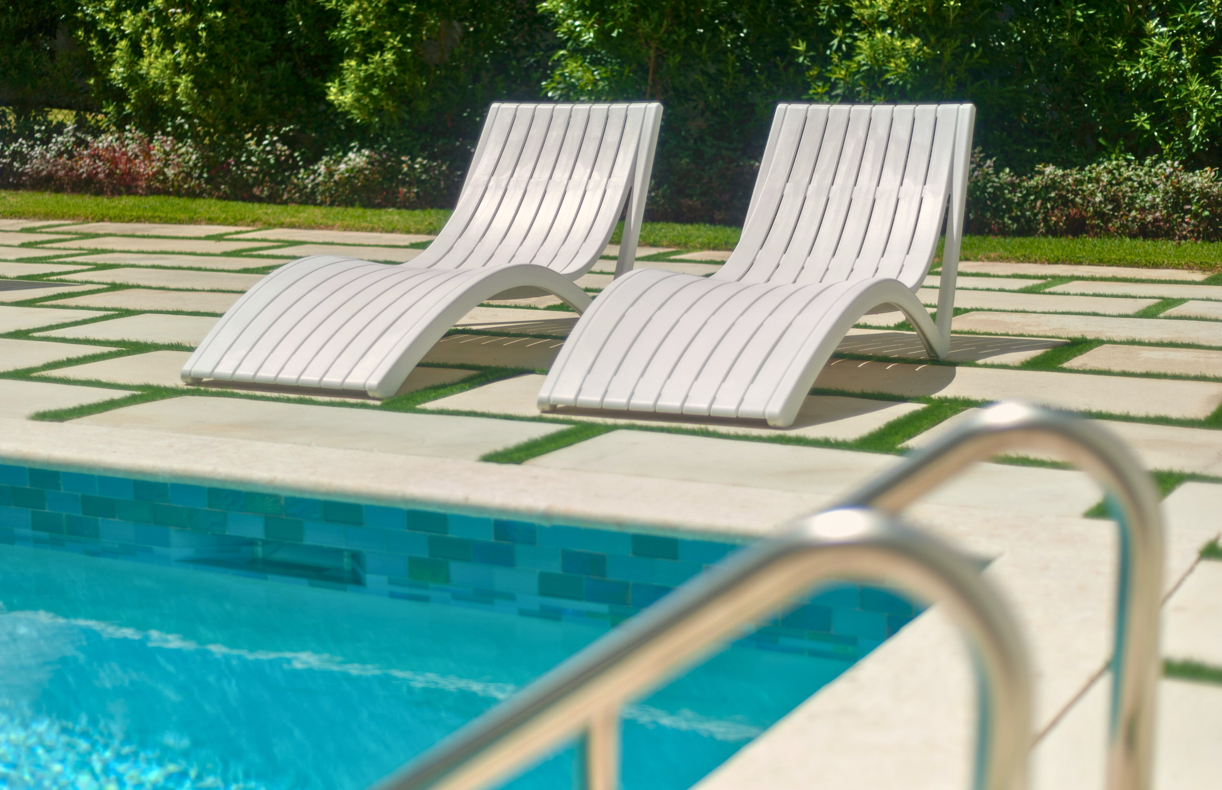 Relax poolside on sleek loungers in a serene resort-style setting
